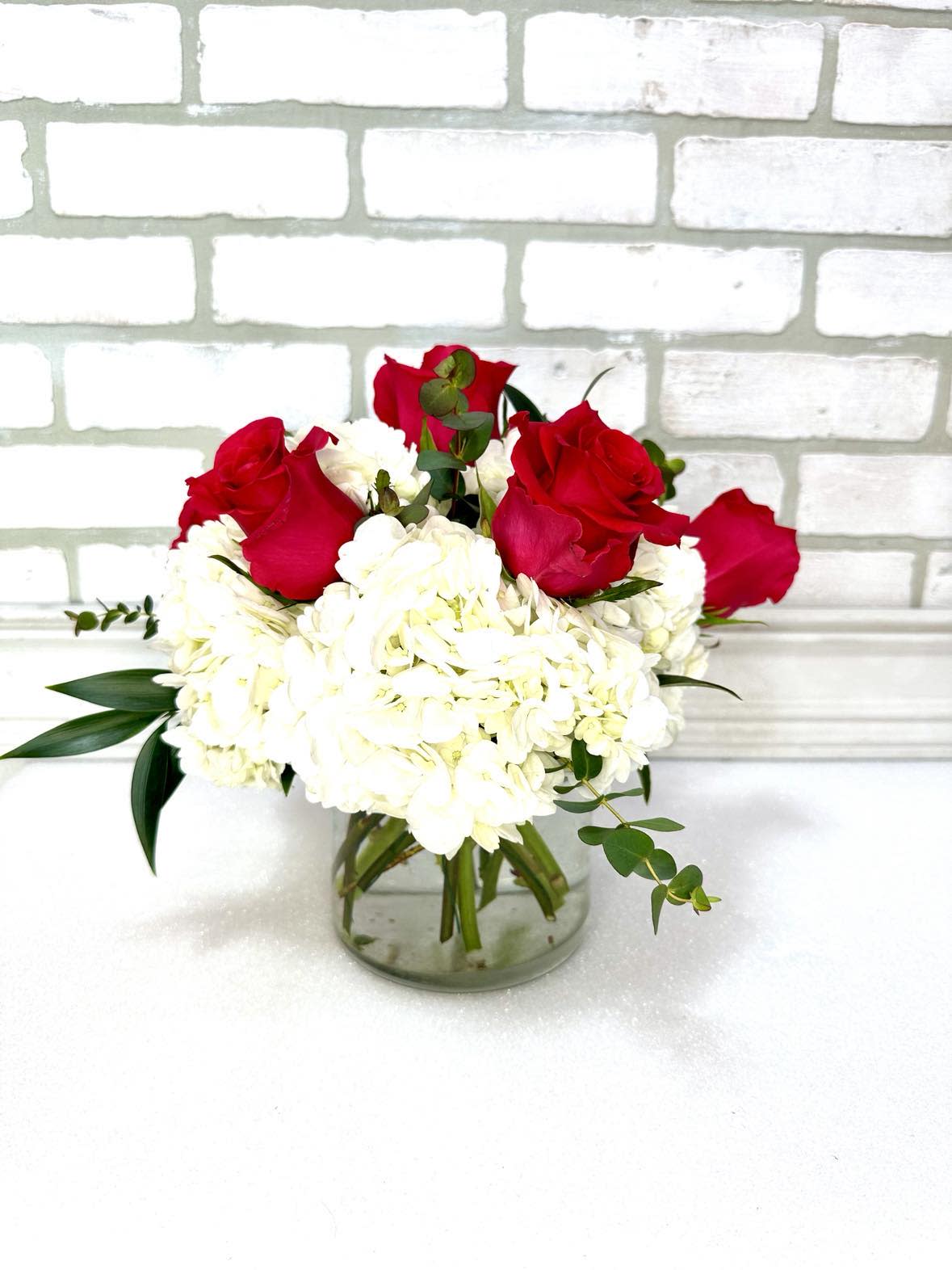 Simplicity with Roses  - Amy's favorite combination - roses and hydrangeas. Simple and elegant. Design includes 6 roses and white hydrangeas. Upgrade to Deluxe or Premium to add more roses and blooms. 