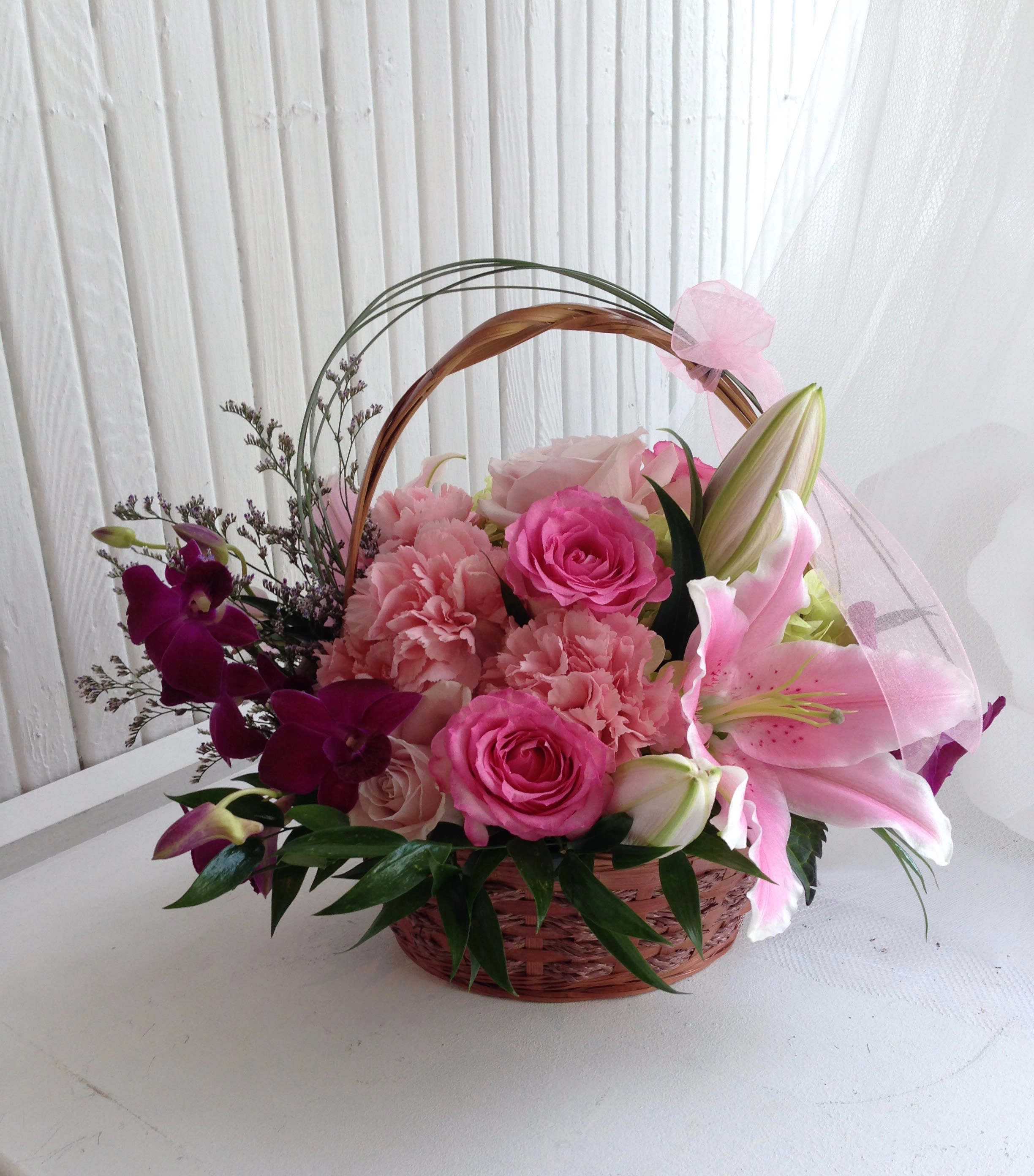 Basket of Joy. A Floral Archist™ original. - Doesn't she deserve a stunning basket filled with love and joy? The many shades of pink in their natural splendor to show her she is THE best!  A Floral Archist™ original.  NOTE: Our flowers and greens are a gift from nature. It’s shade and depth might vary, design, aesthetic and value remains the same.  In support of our efforts to aide in the preservation of our planet, PJf uses Fair Trade flowers, Plants, and Recycled containers.