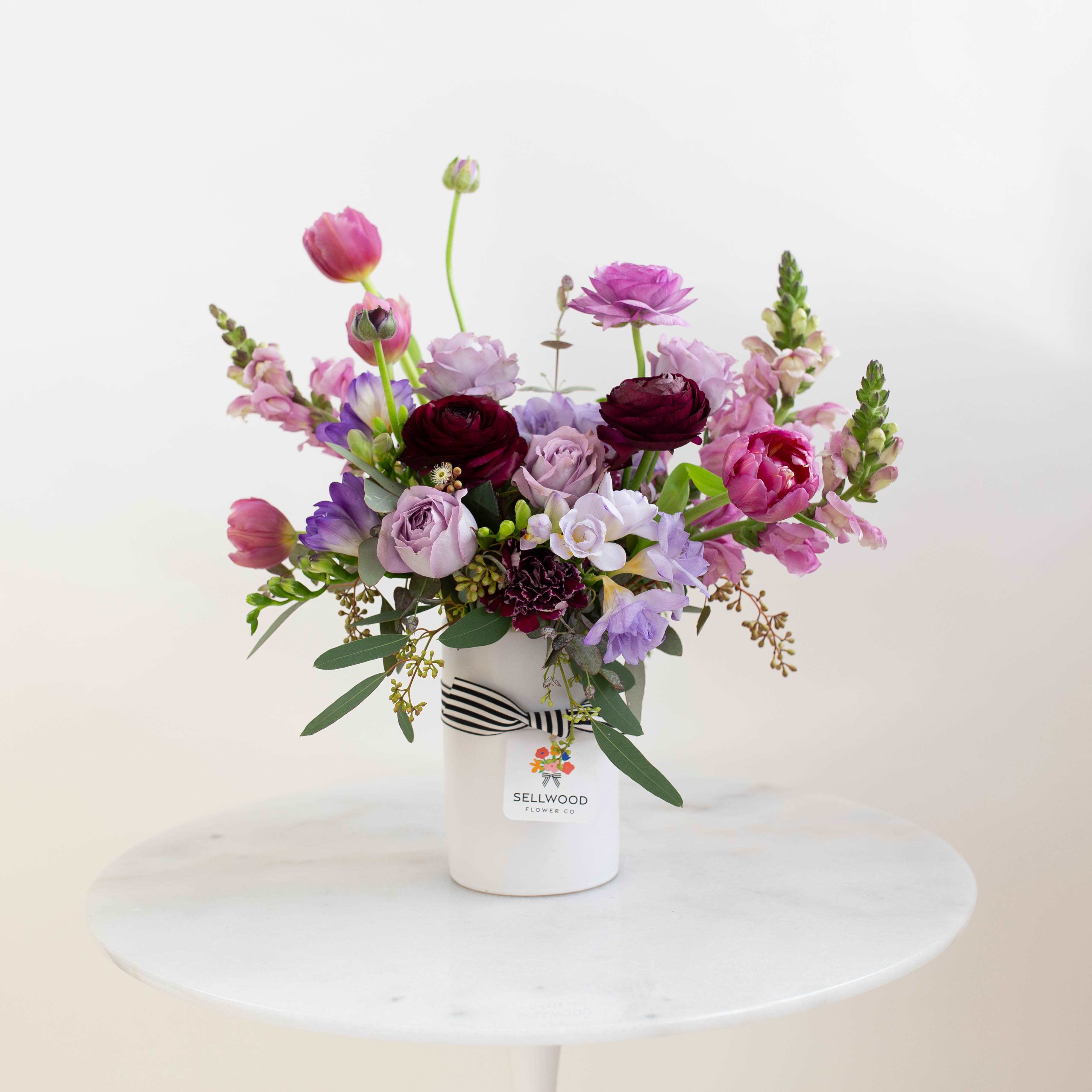 The Mary Lou - Our lavender and purple blooms really make their space pop with color and leave your recipient wowed, a sure way to win them over for Mother’s Day!