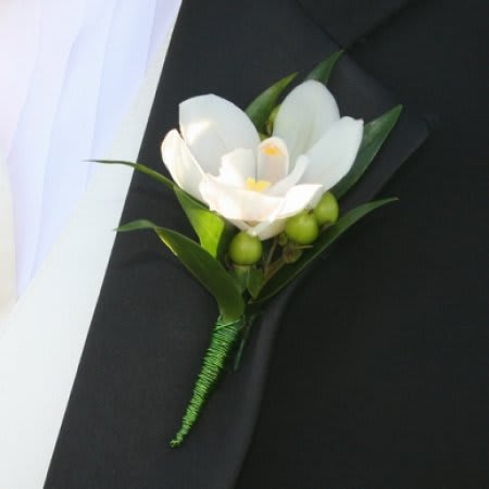 Mini White Orchid Boutonniere #5 Mini White Orchid Boutonniere #5 - This beautiful boutonniere is made with a mini white orchid and greenery with your choice of a pin-on or magnetic attachment piece. Boutonnieres and corsages can be made with any colour accent and ribbon. Please call us for more information or specify colours of outfit/dress in the "Florists' Instructions" section of the check out page.