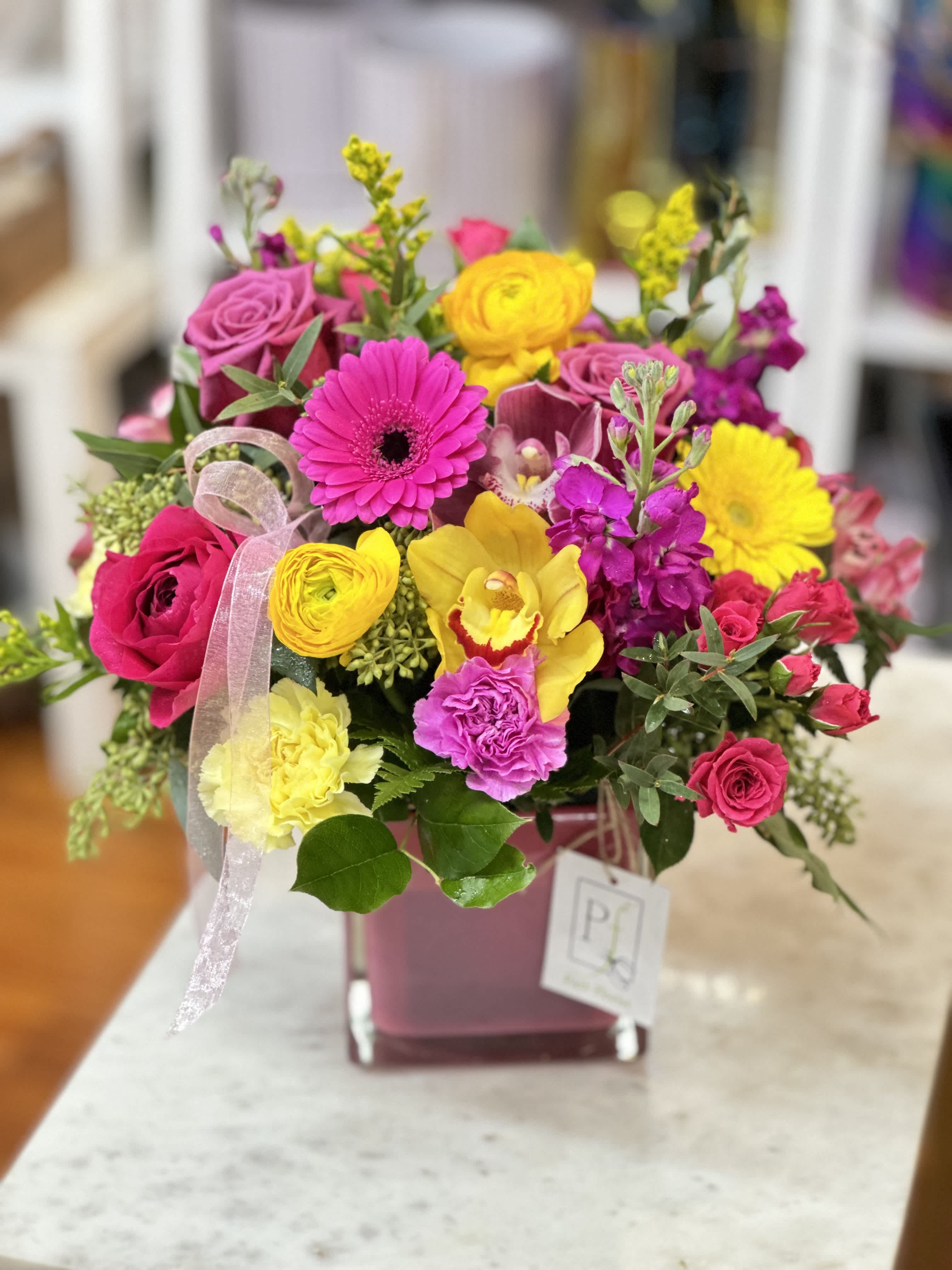 A Mother's Love - There's nothing that compares to a Mother's Love. The same can be said for this arrangement which contains a unique assortment of cymbidium orchids, roses, ranunculus, gerbera daisies, spray roses, carnations, and solidago. Show her how unique and special she is to you this Mother's Day season.