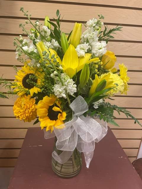 Yellow Sun - Mixed cut flowers with yellow lilies, white stock, sunflowers, and yellow daisies in vase with a bow
