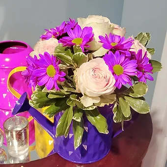 Beautiful Lady - Beautiful pink roses, puple daisy and variegated greenery in a lovely, functioning watering can. Arrangement will be made in any one of the 4 colors avaliable.  Requests will be honored in the notes on a first come first serve basis.