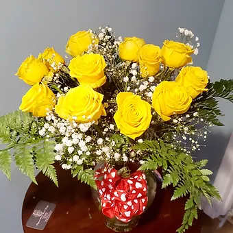 Yellow Roses - Dozen magestic yellow roses with babysbreath and leatherleaf, vased.  Bow can be added based on occasion.
