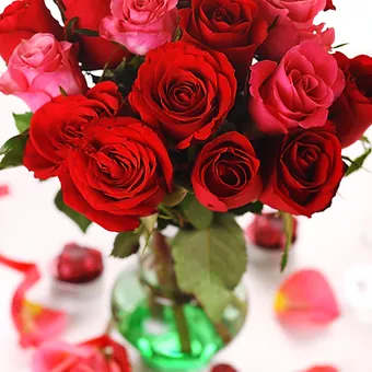 Rouge in bloom - 18 beautiful deep pink and red roses arranged in a beautiful glass vase.