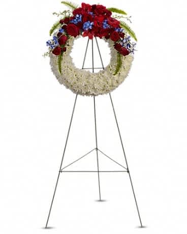 Reflections of Glory Wreath - A stunning display of patriotism, strength and sympathy. This red, white and blue wreath delivers a lovely message about the dignity of the deceased. A lovely array of flowers such as blue hydrangea, red roses and spray roses, delicate blue delphinium, red gladioli, white cushion spray chrysanthemums and more create a circle of serene beauty.