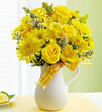 Pitcher of Sunshine - Product ID: 91358   EXCLUSIVE Keep the clouds away with this sunshine yellow arrangement of fresh roses, cremones, alstroemeria and daisy poms, hand-designed by our florists in a reusable white ceramic pitcher. A refreshing surprise that celebrates the bright side of life. Bright bouquet of roses, cremones, alstroemeria, daisy poms, solidago, monte casino and variegated pittosporum Hand-designed by our florists in a stunning, food-safe white handled ceramic pitcher; measures 7.75&quot;H The food-safe pitcher can be reused to serve refreshing beverages, to hold kitchen utensils or for Mom to display more springtime bouquets (see above images for examples of after use) Features a festive twist of a fresh lemon in the vase Large arrangement measures approximately 19&quot;H x 16&quot;W Medium arrangement measures approximately 17&quot;H x 14&quot;W Small arrangement measures approximately 16&quot;H x 12&quot;W Our florists select the freshest flowers available so floral colors and varieties may vary