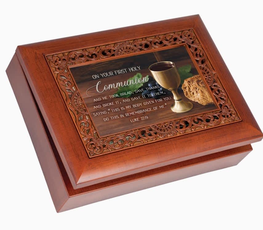 Communion - Gorgeous musical keepsake box is an excellent gift choice. Box is a curved bevel style with woodgrain finish. The hinged lid is also a photo frame, under glass, featuring the sentiment: On your first holy communion/And He took bread, gave thanks and broke it, and gave it to them, saying, this is My body given for you; do this in remembrance of Me; Luke 22:19. Frame area of lid is intricate filigree with a wood-tone finish. Print can easily be changed out for a 6x4 photo. Inside box is a small compartment with clear glass top that shows the high quality Sankyo musical movement. When key under box is wound, music will play when lid is open and stop when it is closed. Plays the song: Ave Maria. Storage compartment has a luxurious black velvety lining. Decorative silver tone legs on bottom are padded to protect furniture. Box is made of a super-sturdy polymer that resists cracking and chipping. Overall size is 8 x 6 x 2 5/8.
