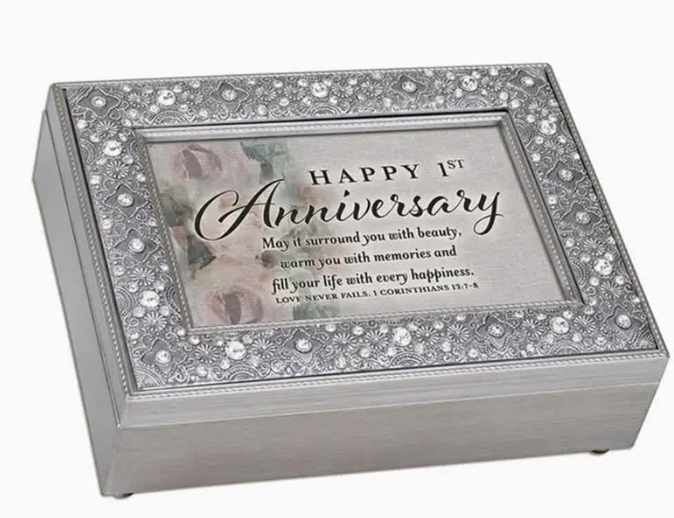 &quot;Happy 1st Anniversary&quot; Music Box - Stamped metal look with brushed silver tone finish; Lid encrusted with rhinestone jewel beads. Jewelry box measures approximately 8 x 6 x 2.75 inches; Window opening hold 4.5 x 6.5 inch personal photo. Black velvet lined interior; Decorative bun feet are padded to protect table top and shelf surfaces. Great for floral arrangements. Song: Amazing Grace