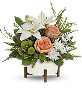 Mod Blooms - Unique in every way, this striking bouquet of peach roses and white lilies is artfully presented in a mid-mod ceramic planter with sculptural wood base.  Peach roses, white asiatic lilies, green button spray chrysanthemums and white button spray chrysanthemums are arranged with grevillea, variegated pittosporum, lemon leaf and seeded eucalyptus. Delivered in Teleflora's Mid-Century planter. Approximately 15&quot; W x 15&quot; H