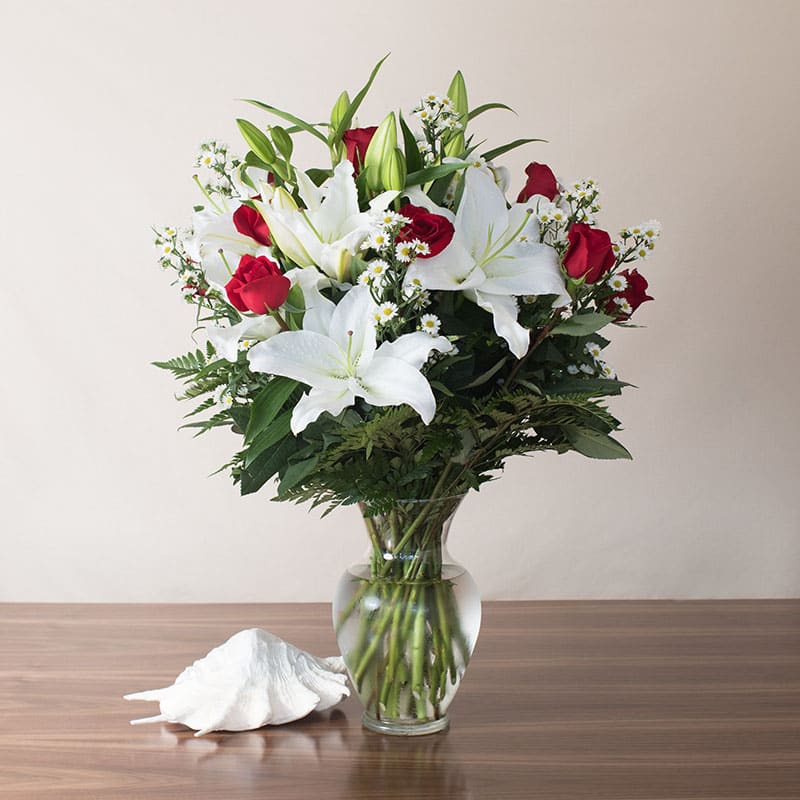 Timeless Romance (Sales Team Favorite) - A spectacular piece featuring premium red Roses and gorgeous white Stargazer Lilies. This striking, elegant arrangement is sure to impress! Standing approx. 27&quot;H x 22&quot;W