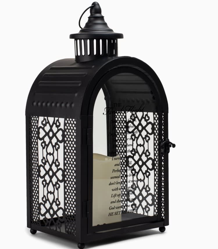 The Final Flight - Exquisite arch shape large black metal lantern features lacy open filigree sides, along with large glass window in back and on the front door. Nicely detailed chimney accent, topped with round carrying handle, is the finishing touch. Glass on door displays a message of comfort, while vintage curved latch holds door securely closed. Lantern is illuminated from within by the soft flickering of a pillar style LED candle, included.  Size of lantern is 16.5&quot; high; 7.5&quot; wide x 6&quot; deep. Candle uses 3 AAA batteries, not included.  Message on lantern: The Final Flight - Don't grieve for me, for now I'm free I'm following a path God laid for me. I took His hand when I heard the call, I turned my back and left it all. Perhaps my time seemed all too brief, don't lengthen it now with undue grief. Lift up your heart and share with me, God wanted me now. He set me free.