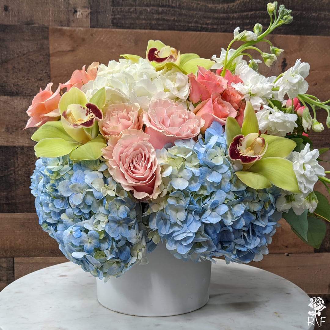 Imagine - The stark contrasts between the certain flowers altogether create for one magical bouquet of flowers and the combinations are simply voluptuously and strikingly beautiful.   The bouquet includes light pink ‘Mondial’ roses, cymbidium orchids, blue and white hydrangeas, peach spray roses, stock, and alstroemeria. It is a great gift at any moment you need to say well done, or that ‘I am Thinking of You