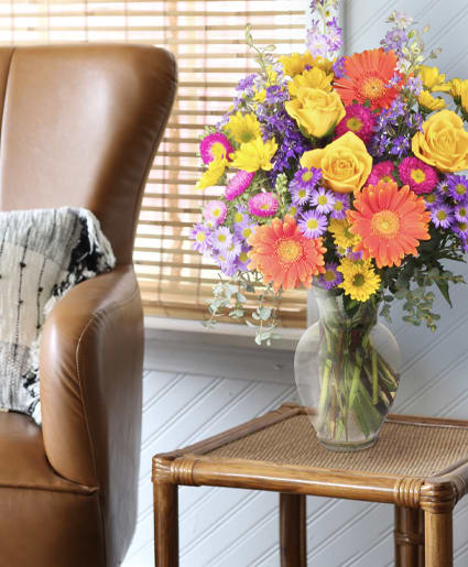 Better Than Ever Arrangement - Make someone smile with this colorful arrangement! With purple larkspur, orange gerberas, hot pink asters, yellow novelty poms, and lavender “Monte Casio” asters, this one-of-a-kind display is sure to dazzle. Send  Better Than Ever tpo someone special today!