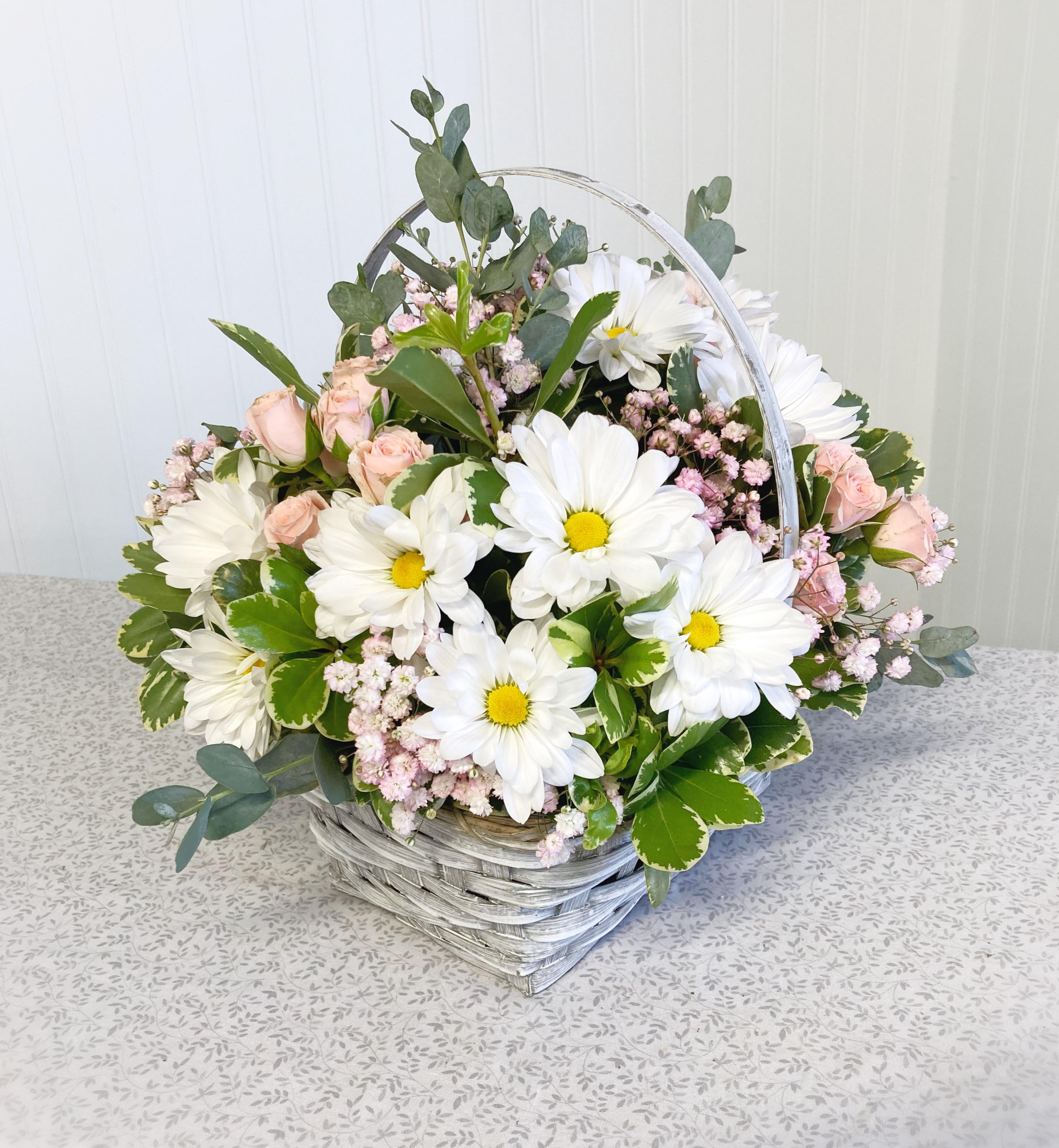 Sweet Daisy Surprise - Send a sweet gift to a friend today with this wicker basket arrangement filled with delicate pink flowers and white daisies!