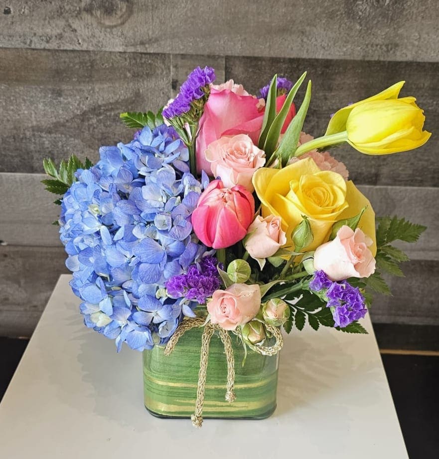 Stacie's Garden Party Stacie's Garden Party - A stunning mix of hydrangea, tulips, roses and spray roses in soft hues. This beautiful arrangement is perfect for any occasion, featuring a harmonious blend of textures and colors that evoke a sense of elegance and sophistication.