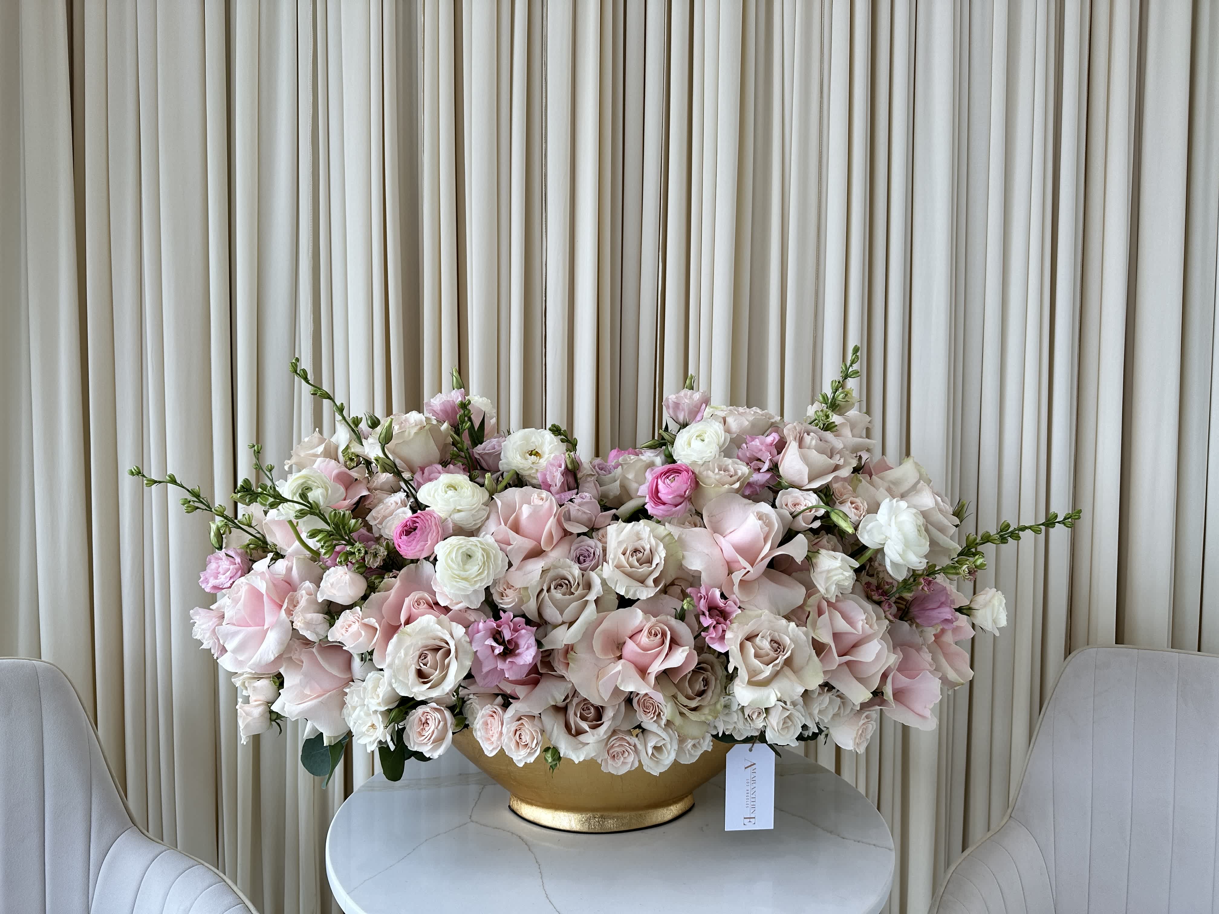 Pink &amp; Pretty - Our Pink &amp; Pretty Posy is a charming way to express your love and appreciation. Featuring a delightful mix of soft pink and Nude roses, lisianthus, and ranunculus, each bloom is carefully chosen for its delicate beauty and soft fragrance. This arrangement is perfect for a coffee table, kitchen island, or anywhere you need a touch of sweetness. Watch as the soft pinks and whites bring a smile to someone's face, reminding them of your thoughtfulness.