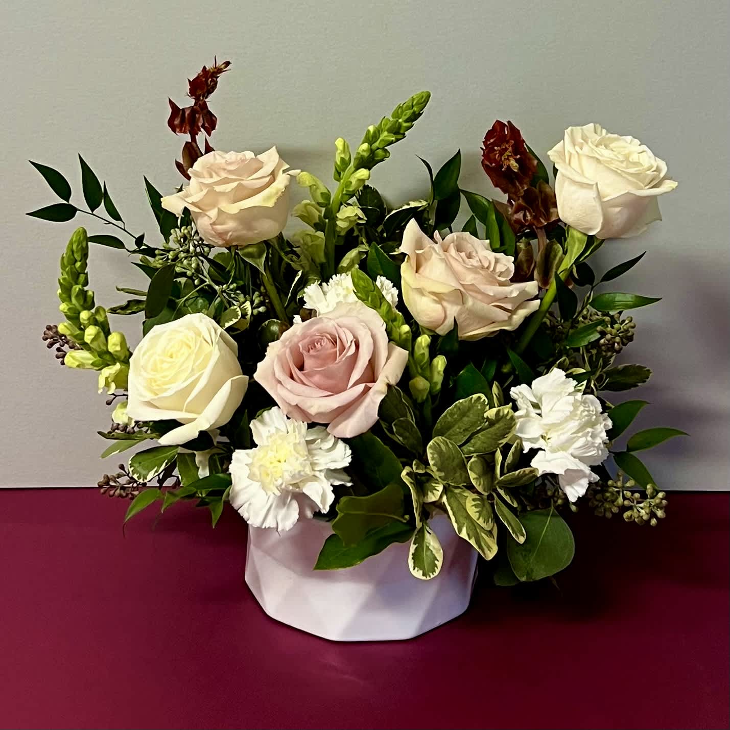 IMAGINE - This flower arrangement is designed in a low white ceramic vase. It has a mix of seasonal flowers and roses. Flower delivery available for the Santa Clarita Valley, and surrounding areas in LA County