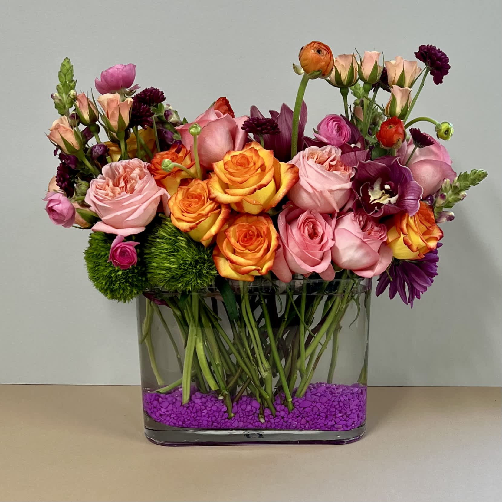 CALIFORNIA SUNRISE - This flower arrangement is designed in a glass vase using premium flowers like roses, orchids and seasonal flowers. 
