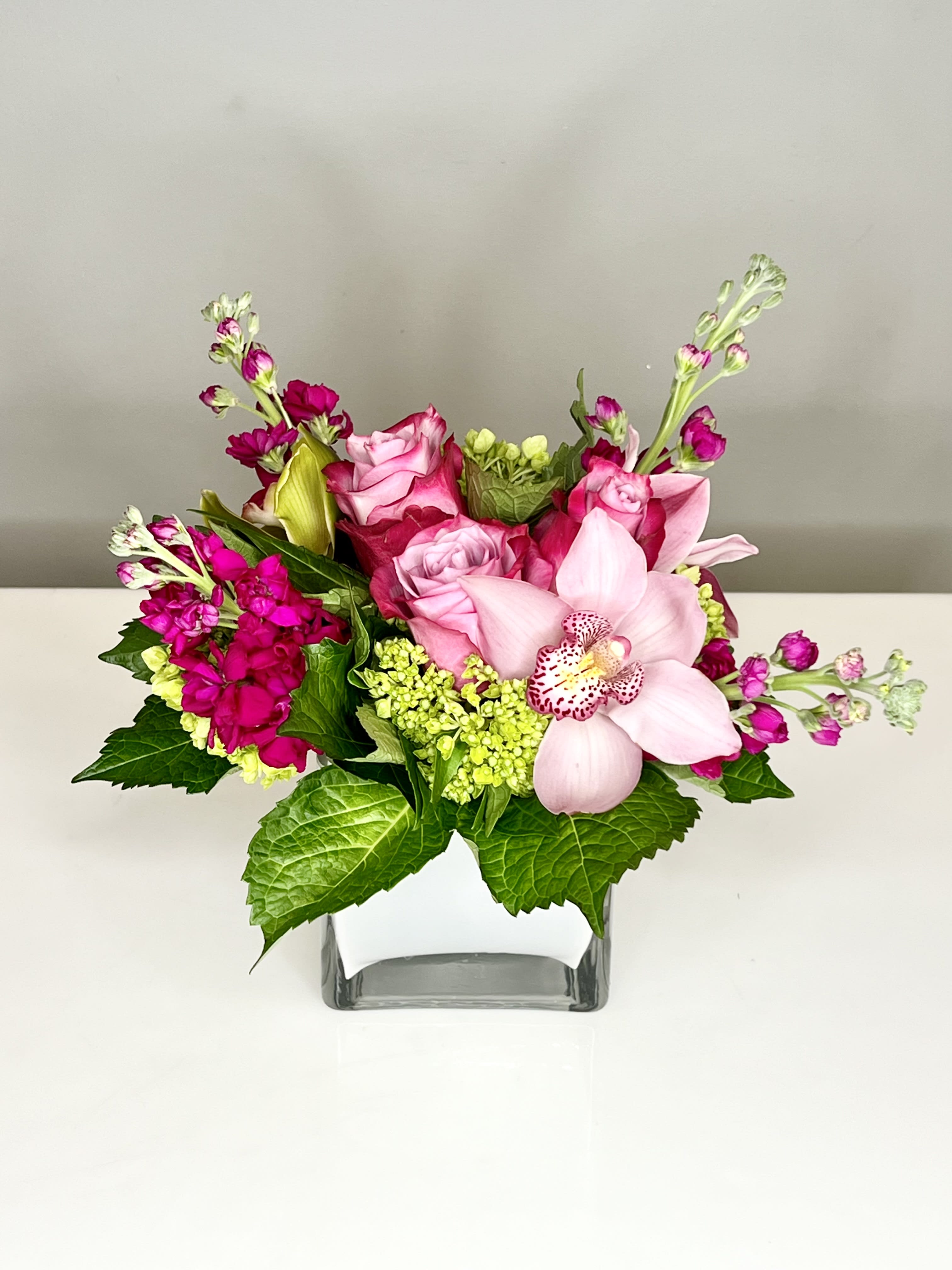 Gigi - Happy and bright arrangement of colorful blooms in a modern glass cube