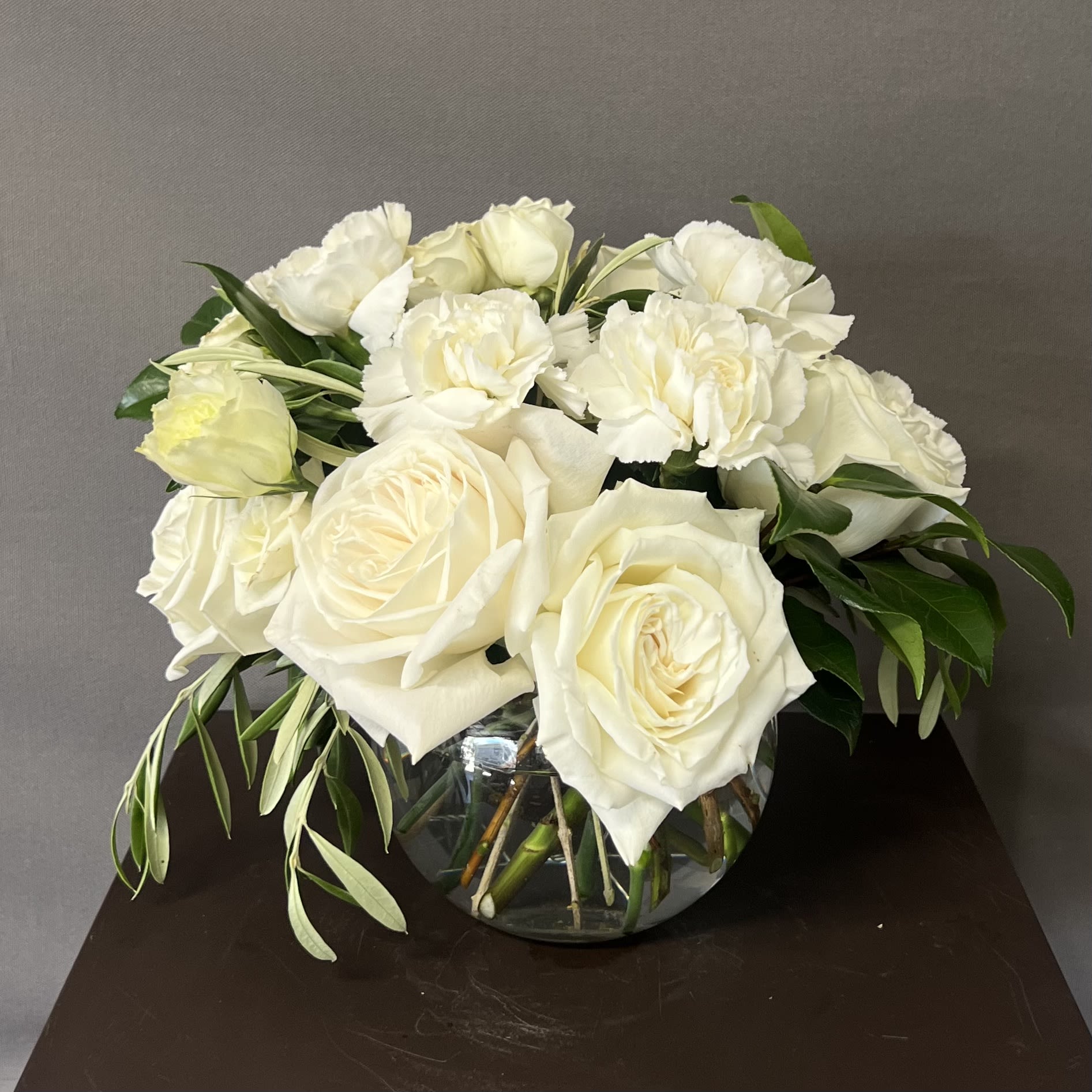 WHITE BUBBLE BOWL - These floral arrangement is designed in a 5&quot; glass bubble bowl and it has a mix of white flowers. 