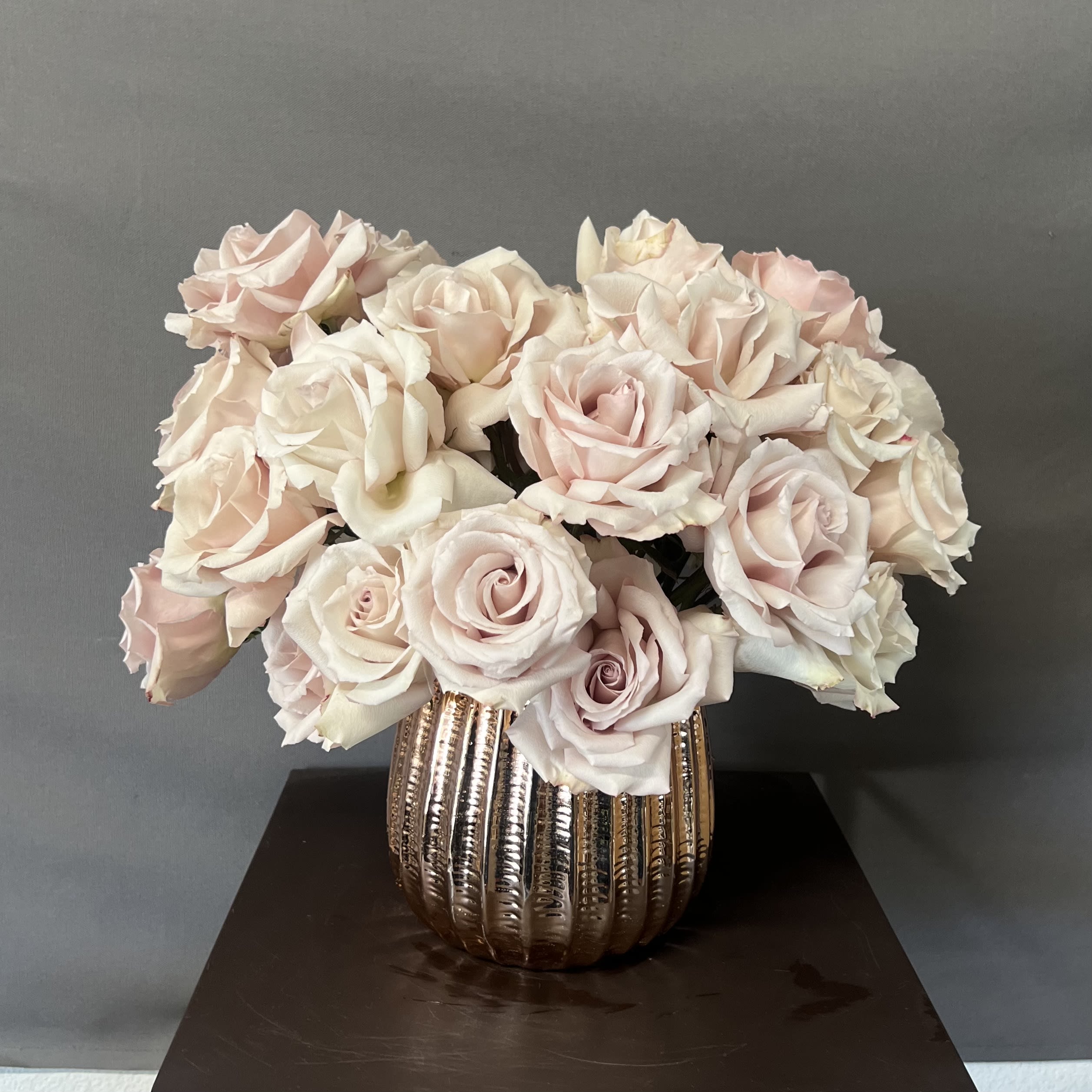 SOFT ELEGANCE - This Lush and elegant floral arrangement is a head turner. The roses used for this arrangement smell amazing and open up beautifully. Roses are arranged in a 6&quot; Rose gold ceramic vase. This considered a medium size arrangement and it has 35-50 Roses. 