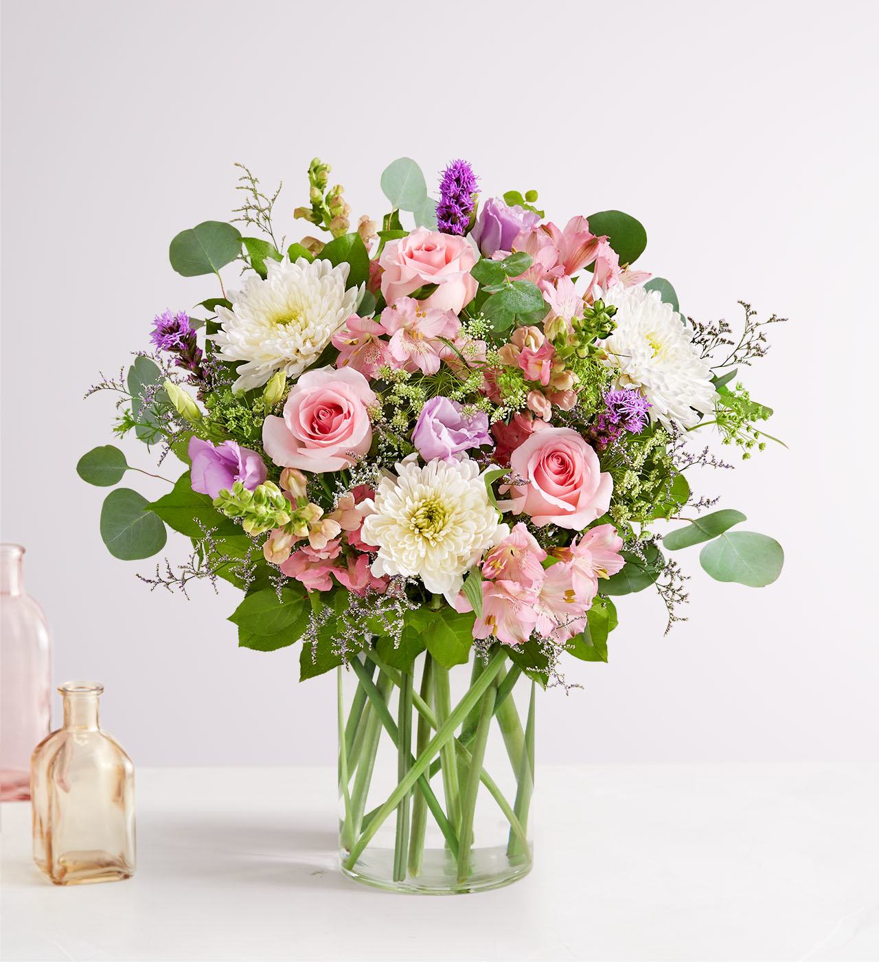 Floral Meadow for Mom - Clear glass vase filled with pink roses, lisianthus, pink spray roses, pink snap dragons, purple liatris, pink alstroemeria, baby's breath, limonium, and mixed greens. 