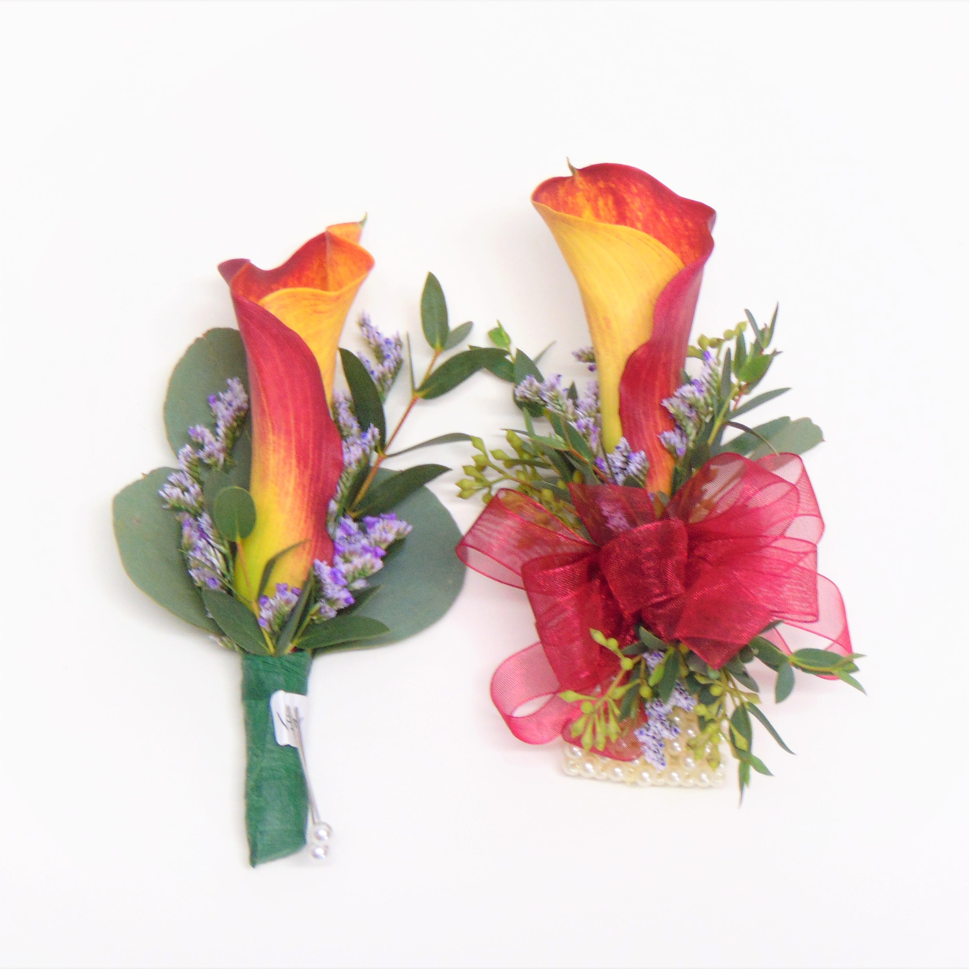 Magic Calla Lily Pair - Burnt Orange and yellow bicolor calla lily boutonniere and matching wrist corsage with burgundy ribbon, limonium and eucalyptus. Corsage is on a standard Wrislet. Standard opiton is pictured. Deluxe option adds bling. Boxes are included.