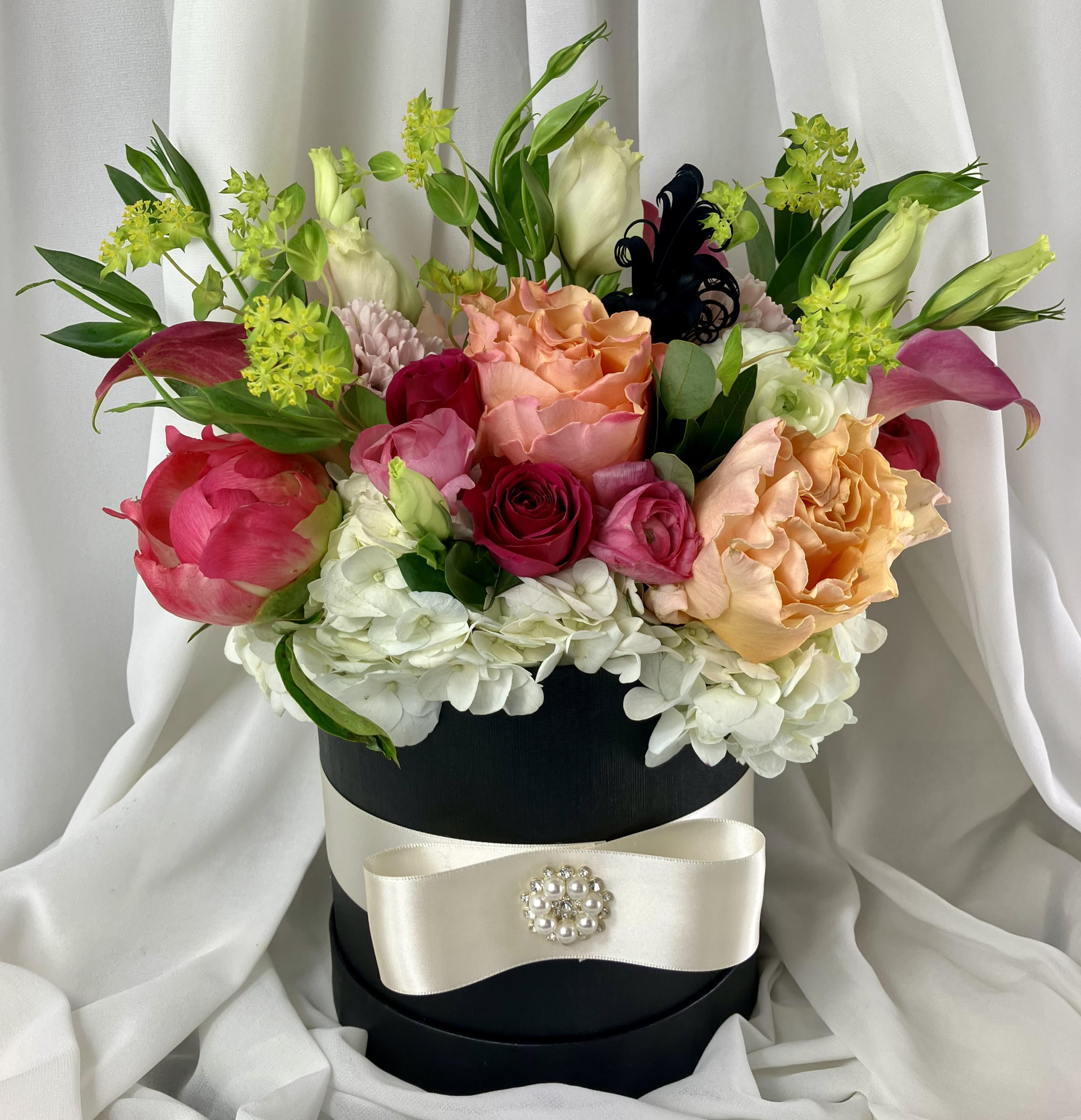 Vintage Hat Box -  Our unique vintage hat box is filled with the seasons freshest and most luxurious florals in our weekly color palette. Our deluxe version includes additional luxurious blooms and orchids.  As always, guaranteed to take your recipients breath away!   THANK YOU for entrusting us with your very special occasion. We take every order personally as if it were going to our own family.  FOR SAME DAY DELIVERY FOR ZIP CODE 76262, PLEASE ORDER BY 2:00 PM. FOR ALL OTHER SURROUNDING ZIP CODES, PLEASE ORDER BY 1:00 PM. All deliveries are made in the afternoons between 1:00 PM - 5:00 PM. If your delivery needs to be at a specified time, we offer &quot;timed delivery&quot; for a fee during the checkout process.  Please be sure to include the RECIPIENT'S CORRECT PHONE NUMBER, (not your phone number, this delays your delivery) gate codes or any other special instructions to ensure a smooth delivery. Due to unreliable Texas weather, House Of Flowers MUST call and schedule your delivery with the recipient. Flowers CAN NOT be left on the porch during the summer. Please try and make sure your recipient will be home at time of delivery. We will attempt delivery once and then offer them an in-studio pickup. Delivery charges are non-refundable. Our top priority is that your recipient receives the most luxurious and long lasting freshest florals they have ever seen. Thank you for your cooperation!
