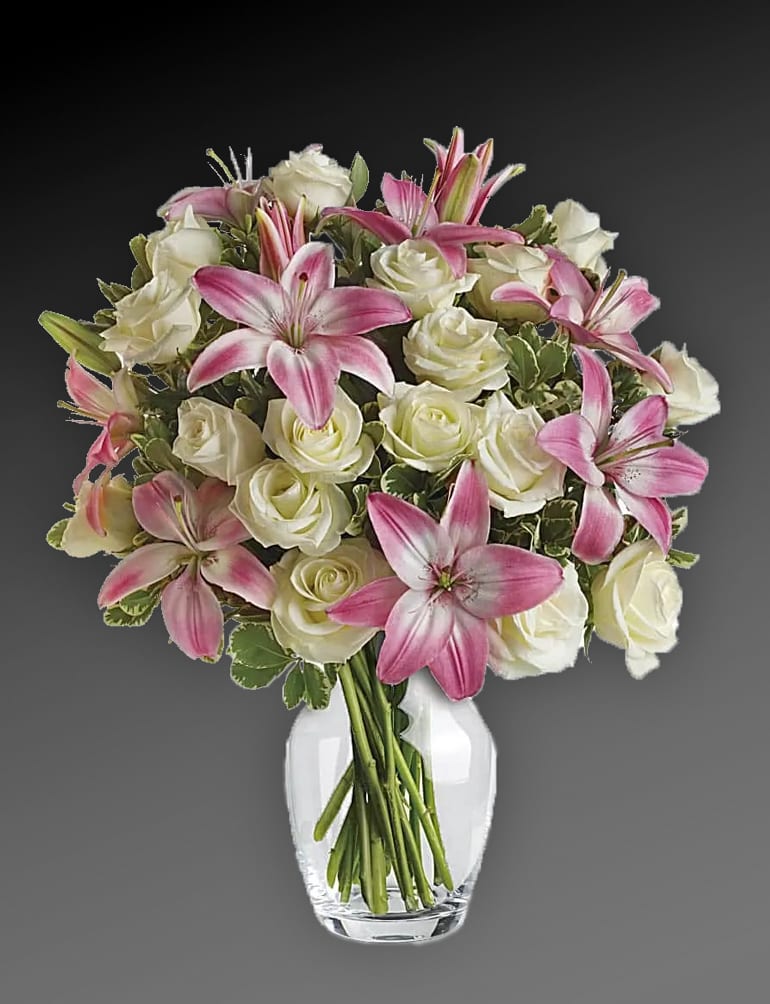 Always a Lady - She'll always be your #1 lady. Remind her just how special she is - send a sensational gift she'll never forget. This beautiful bouquet of fragrant pink lilies and lush white roses is sure to make an impression! One dozen white roses are mixed with pink asiatic lilies and variegated pittosporum in a classic clear glass rose vase. Orientation: All-Around