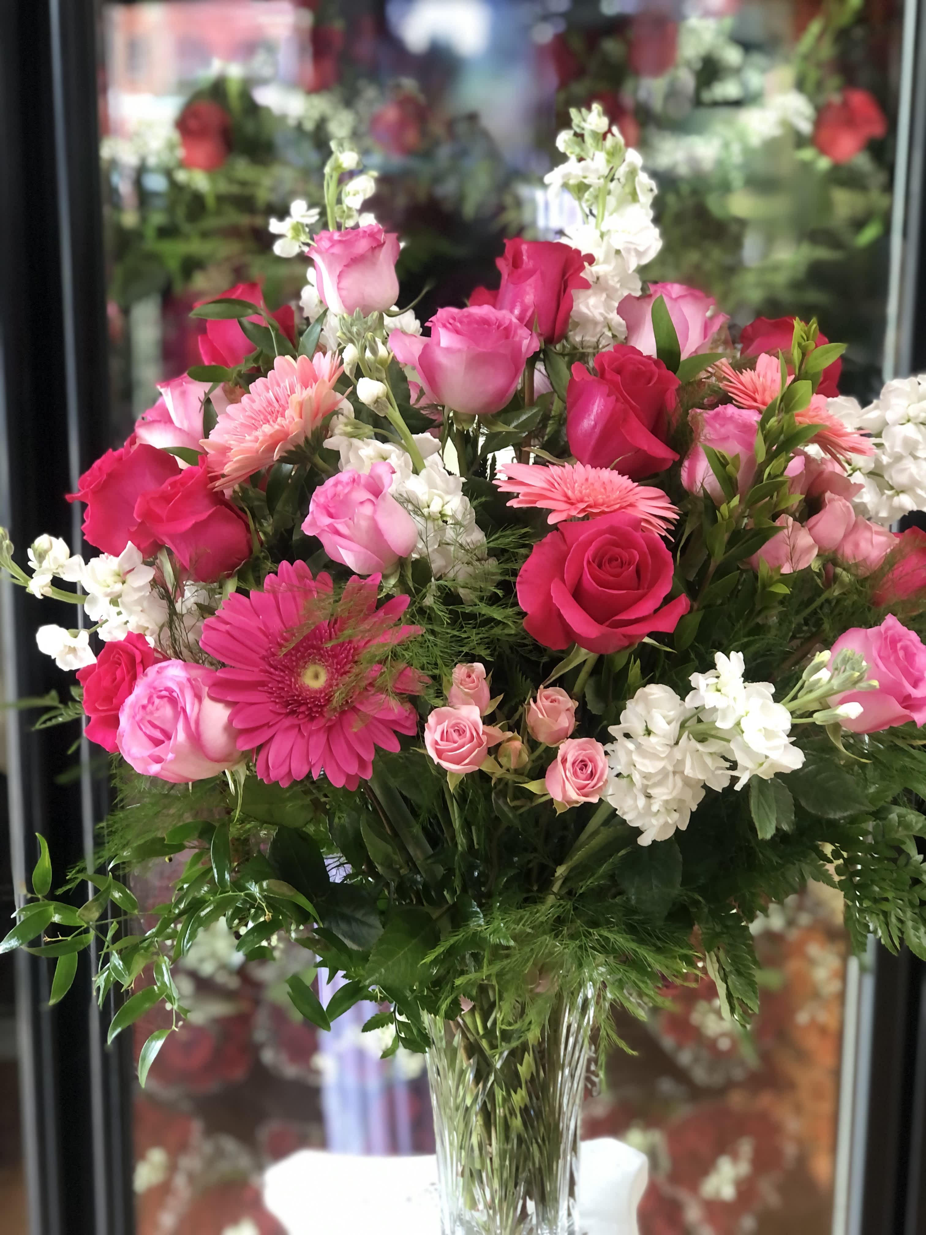 Heartfelt Embrace Heartfelt Embrace - The "Heartfelt Embrace" arrangement combines red and pink roses with mini pink roses, stock, daisies, and leather leaf, enveloped in lush greenery for a warm and affectionate display.