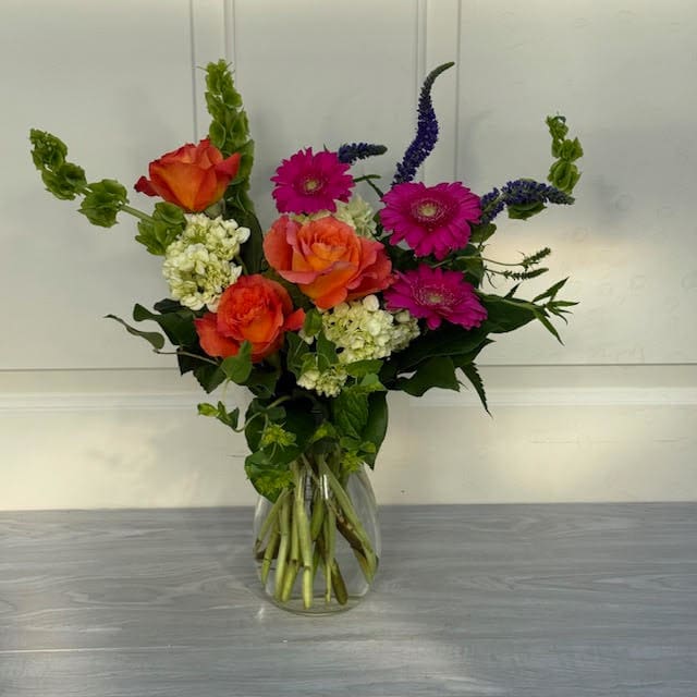 Garden Bliss  - Bring the beauty of spring indoors with our Garden Bliss Floral Arrangement. Featuring roses, hydrangea, and gerbera daisies in bright, colorful shades, this lively bouquet adds a burst of vibrant nature to your space.