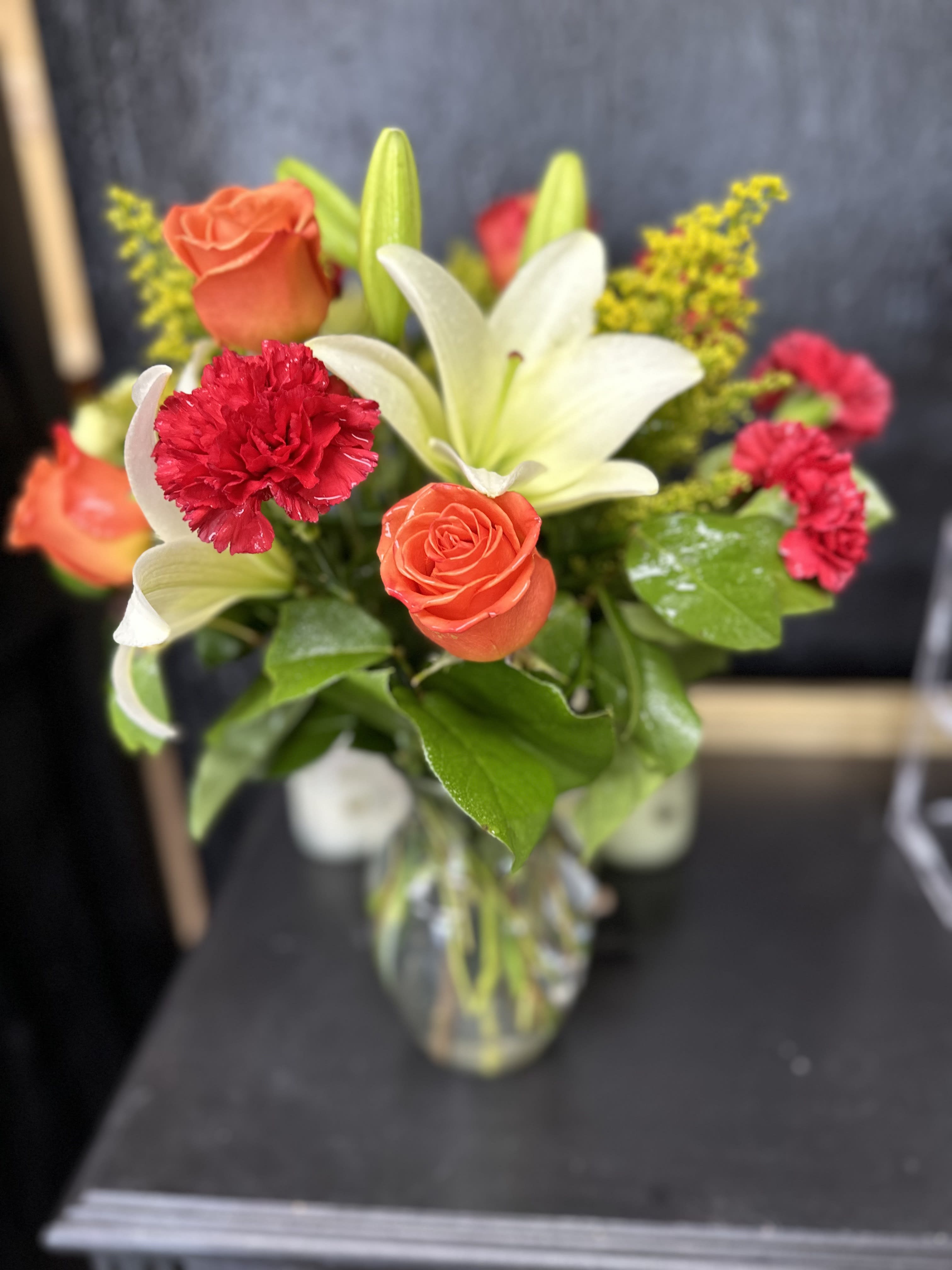 Sunset Sky - Add a bright touch to any room with a fiery mix of yellow, orange and red flowers – including roses and lilies – that’s guaranteed to warm up someone’s day. A bright floral mix that’s as pretty as a summer sunset.