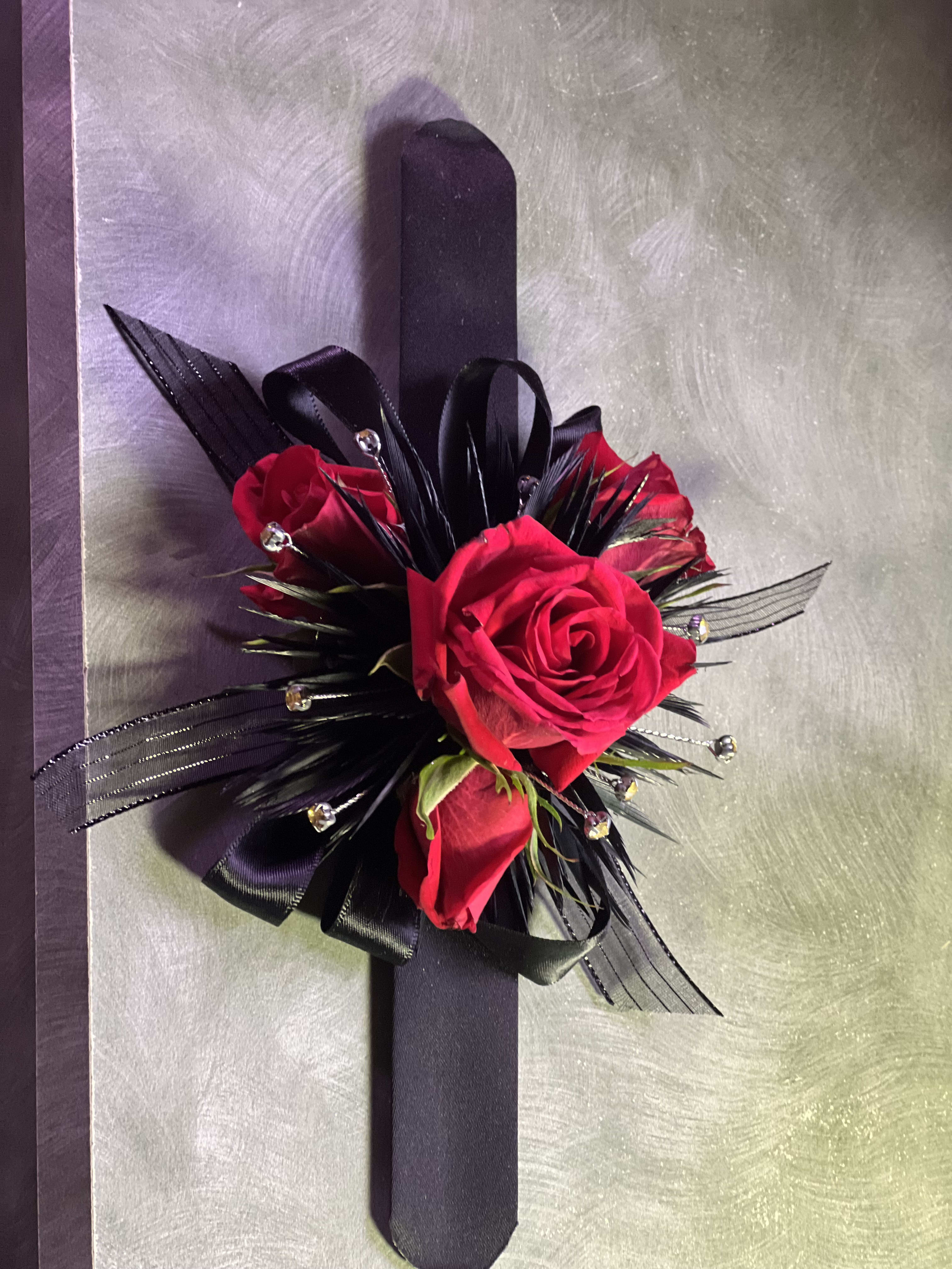 Black Prom Corsage - Just in time for Prom Season, Our Black Prom (or homecoming) Corsage. Fitted with rhinestones, black feathers and ribbon on a black slap bracelet.  Comes with spray roses. Custom created with you in mind.