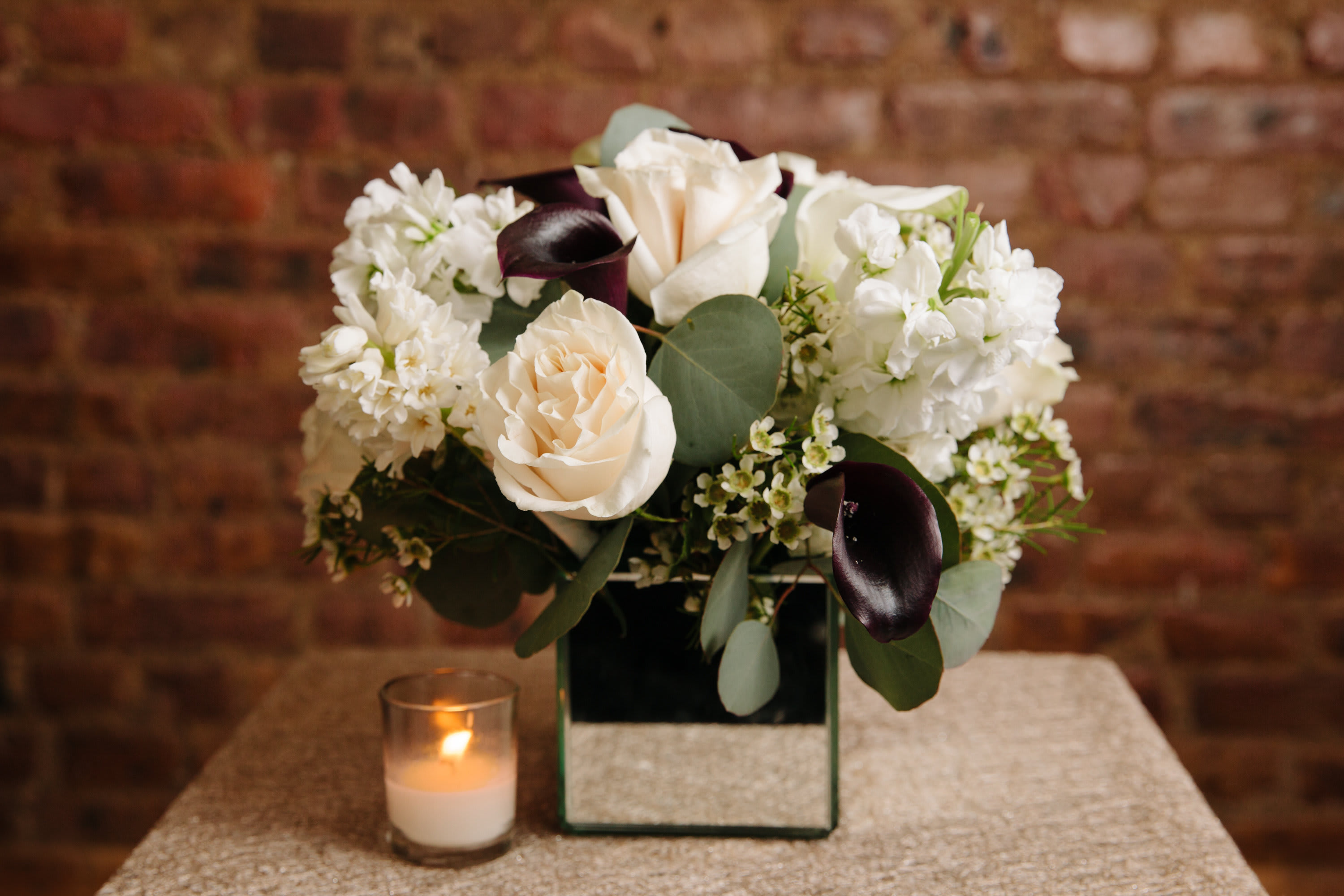 Deep Desire  - An elegant arrangement of white seasonal flowers with a deep touch displayed in a decorative mirror vase. 