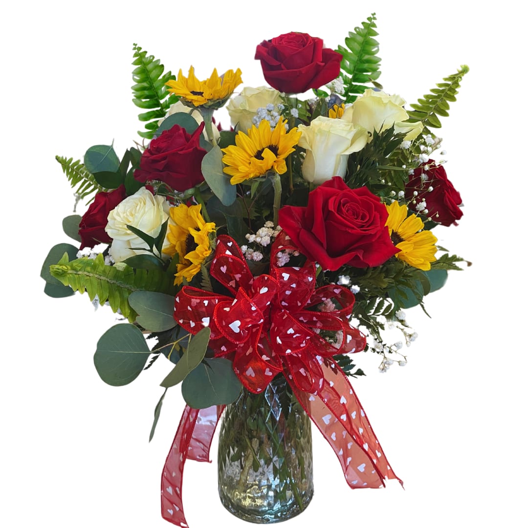 Sun Kissed - This charming arrangement features six velvety red roses, six pristine white roses, and six sunny sunflowers. Nestled within lush greenery and accented by a playful red ribbon, the Sun Kissed Bouquet radiates love, and joy.