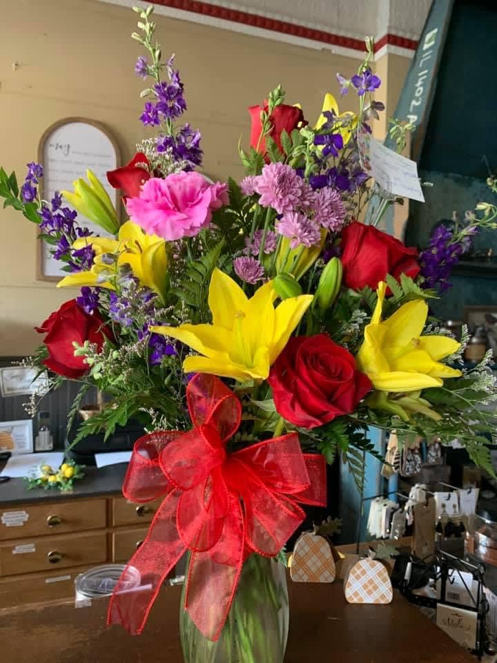 Floral Embrace Bouquet Floral Embrace Bouquet - A beautiful arrangement of bright yellow lilies complimented with red roses and brightly colored flowers