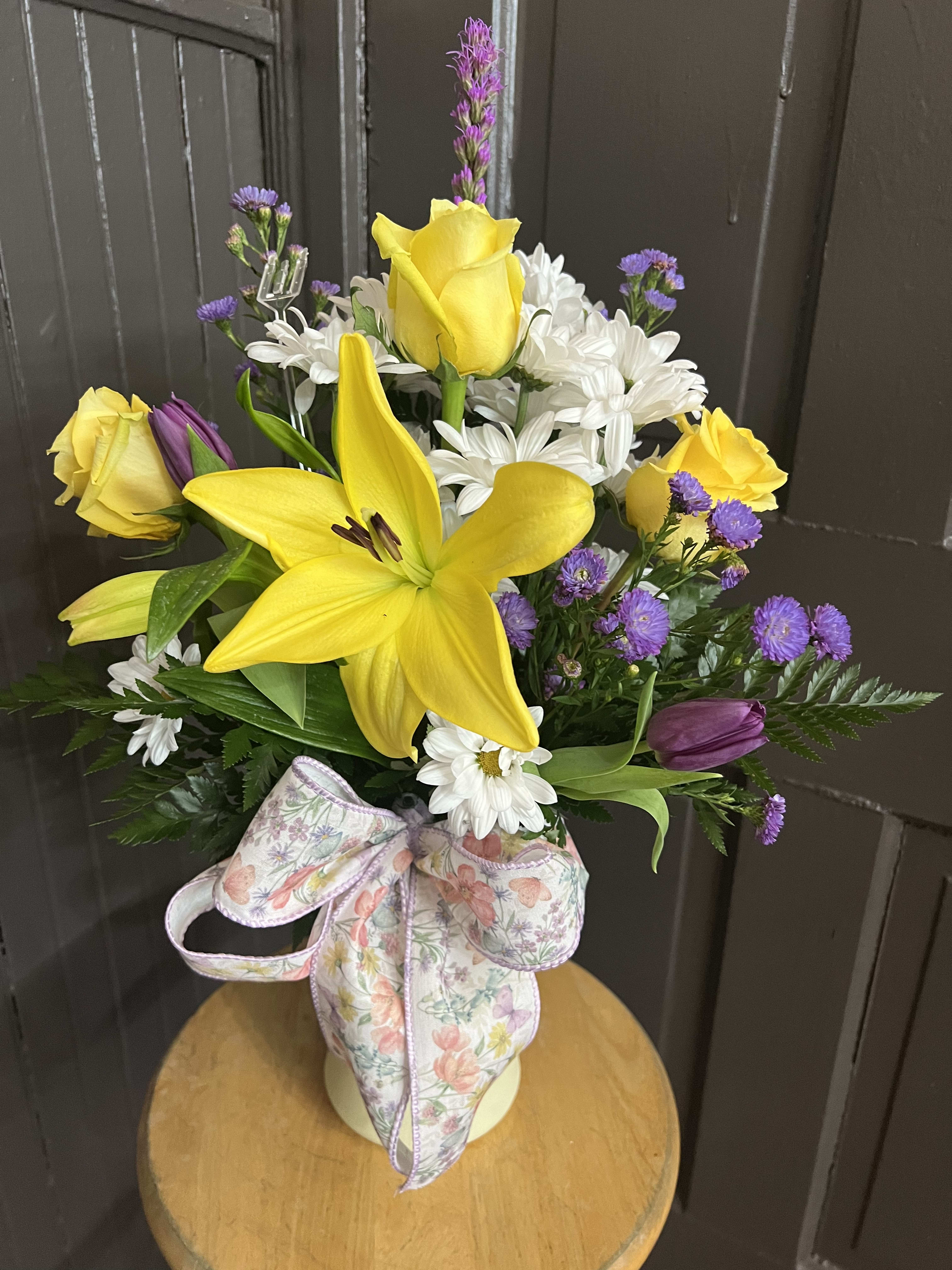 Purple Sunshine Bouquet Purple Sunshine Bouquet - A mix of yellow and purple flowers arrangement in a vase with a matching bow