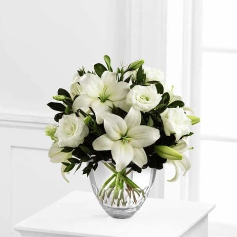 WHITE ELEGANCE WHITE ELEGANCE - Exuding a soft sophistication, this bouquet of white Asiatic Lilies and double lisianthus are brought together with fresh, lush greens and arranged to perfection in a clear modern glass vase, creating a beautiful way to offer your special recipient an expression of grace and elegance. Size: 12''x 12H