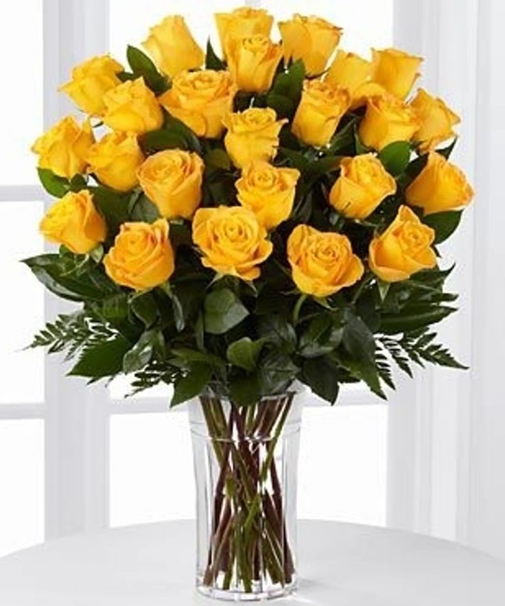 2 Dozen Yellow Roses - These harmonious, yellow flowers are Ecuadorian Roses carefully hand selected and arranged in their natural beauty in a clear, glass vase. The contrast between the bright yellow flowers and the clear, glass vase creates a unique, visually appealing atmosphere. 