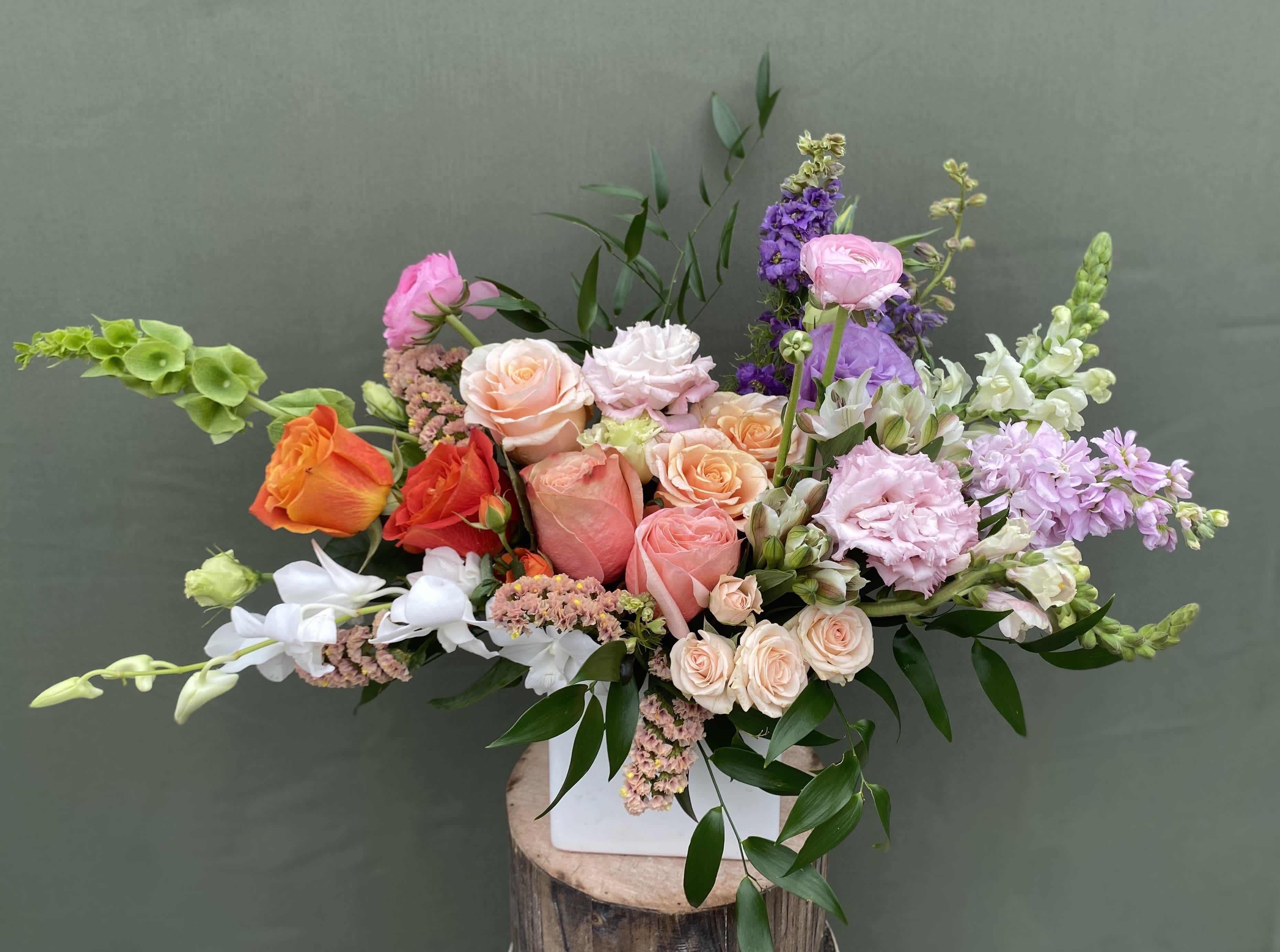 Summer in the Sun Summer in the Sun - This arrangement is perfect for bringing the beauty of summer into your home. It includes roses, lisianthus, ranunculus, snapdragons, orchids and stocks. Enjoy the stunning mix of flowers that will brighten up any room in your house.