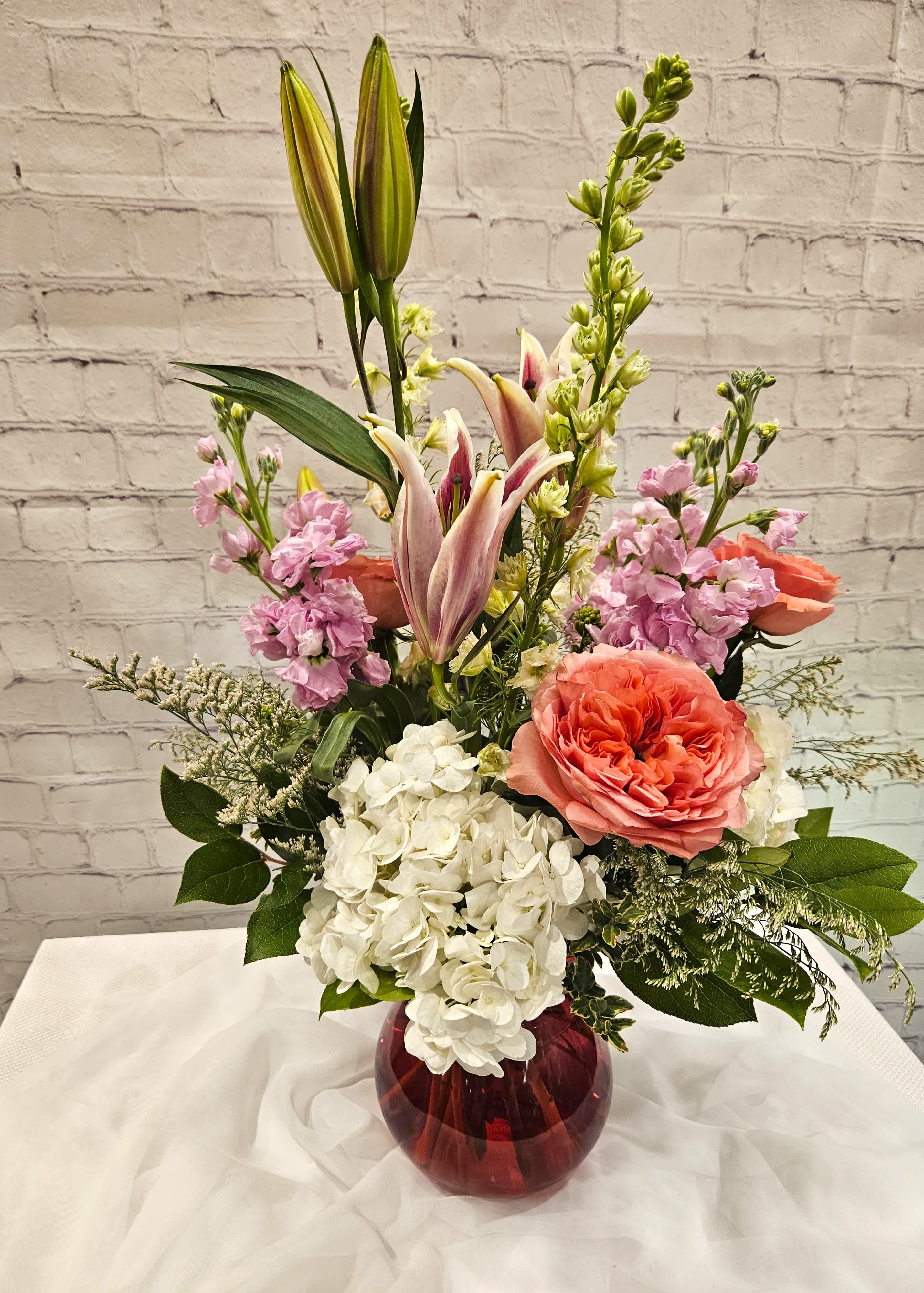 Expressions of Love - A bold design expressing the height of your love.  Featuring Pink xpression roses, starfighter lilies, hydrangeas, stock, larkspur and more.    Metcalfe's exclusive design