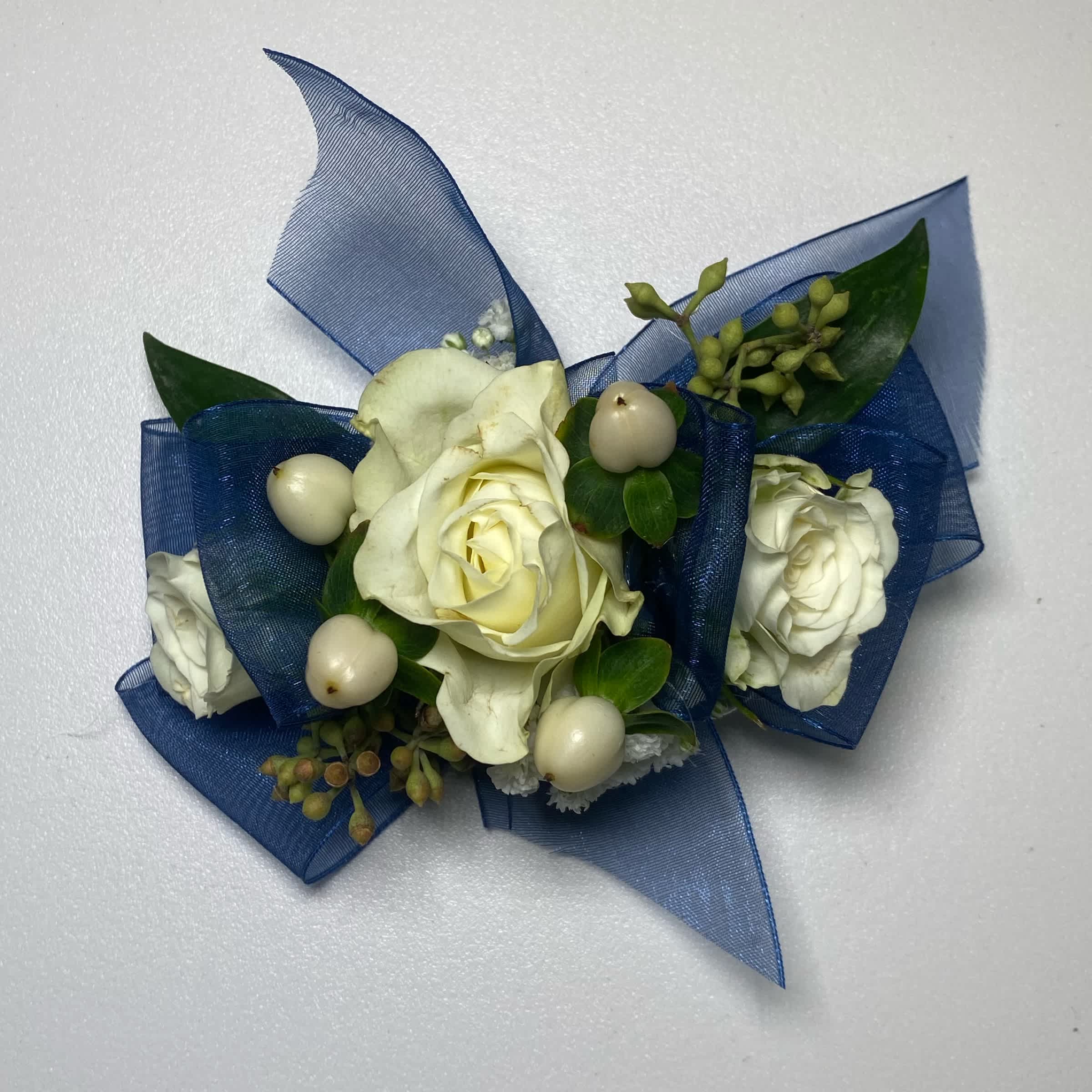 Navy Blue/ White Rose Wrist Corsage - Prom/ Wedding - This White Rose Corsage Includes an Adult Size Elastic Wristband, Navy Blue Chiffon Ribbon, White Spray Roses, Hypericum Berries, Gentle Greenery and Seeded Eucalyptus. Or as Similar as Possible.