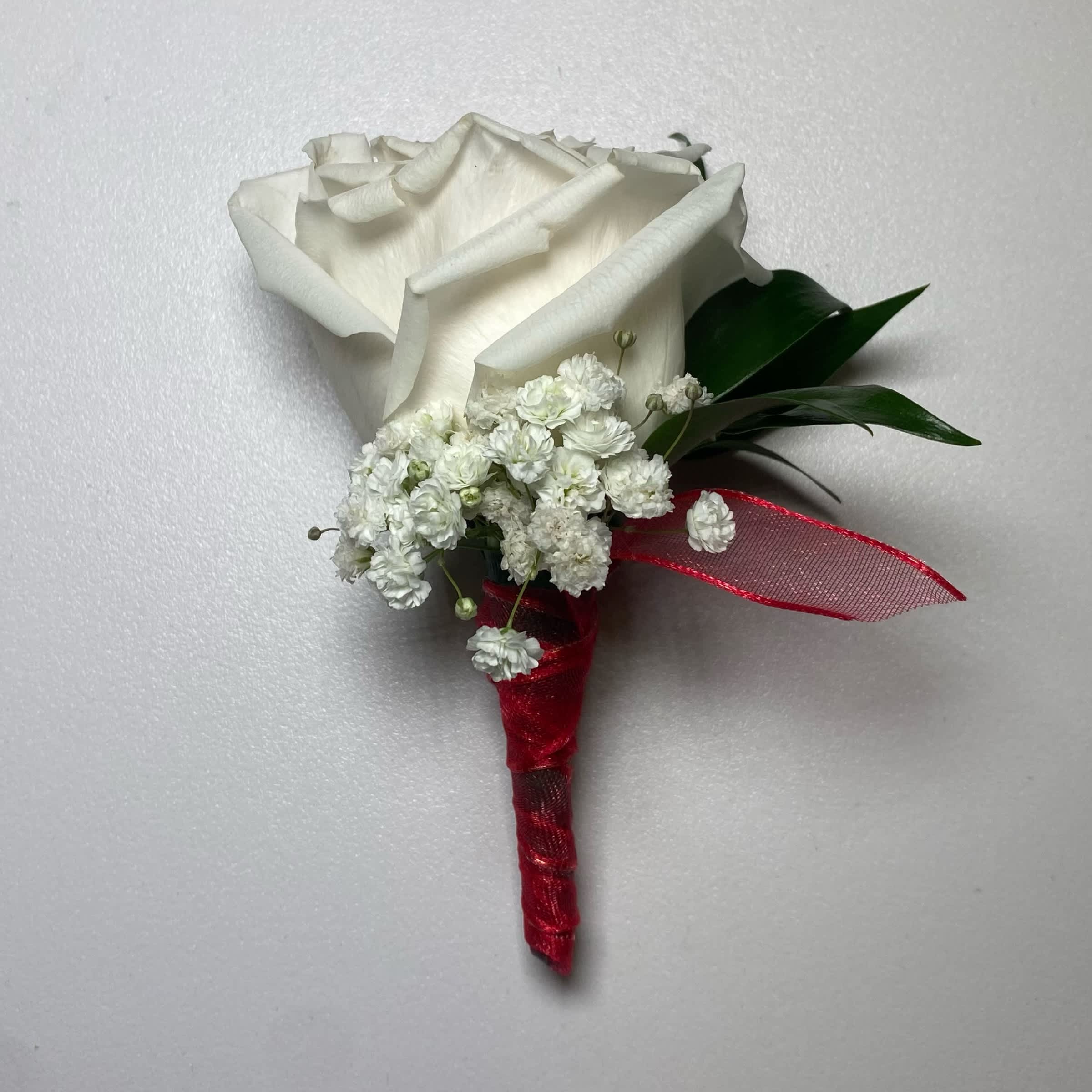 Red/ White Rose Boutonniere - This White Rose Boutonniere Includes, Red Chiffon Ribbon, White Rose, Babies Breath, and Gentle Greenery. Or as Similar as Possible.