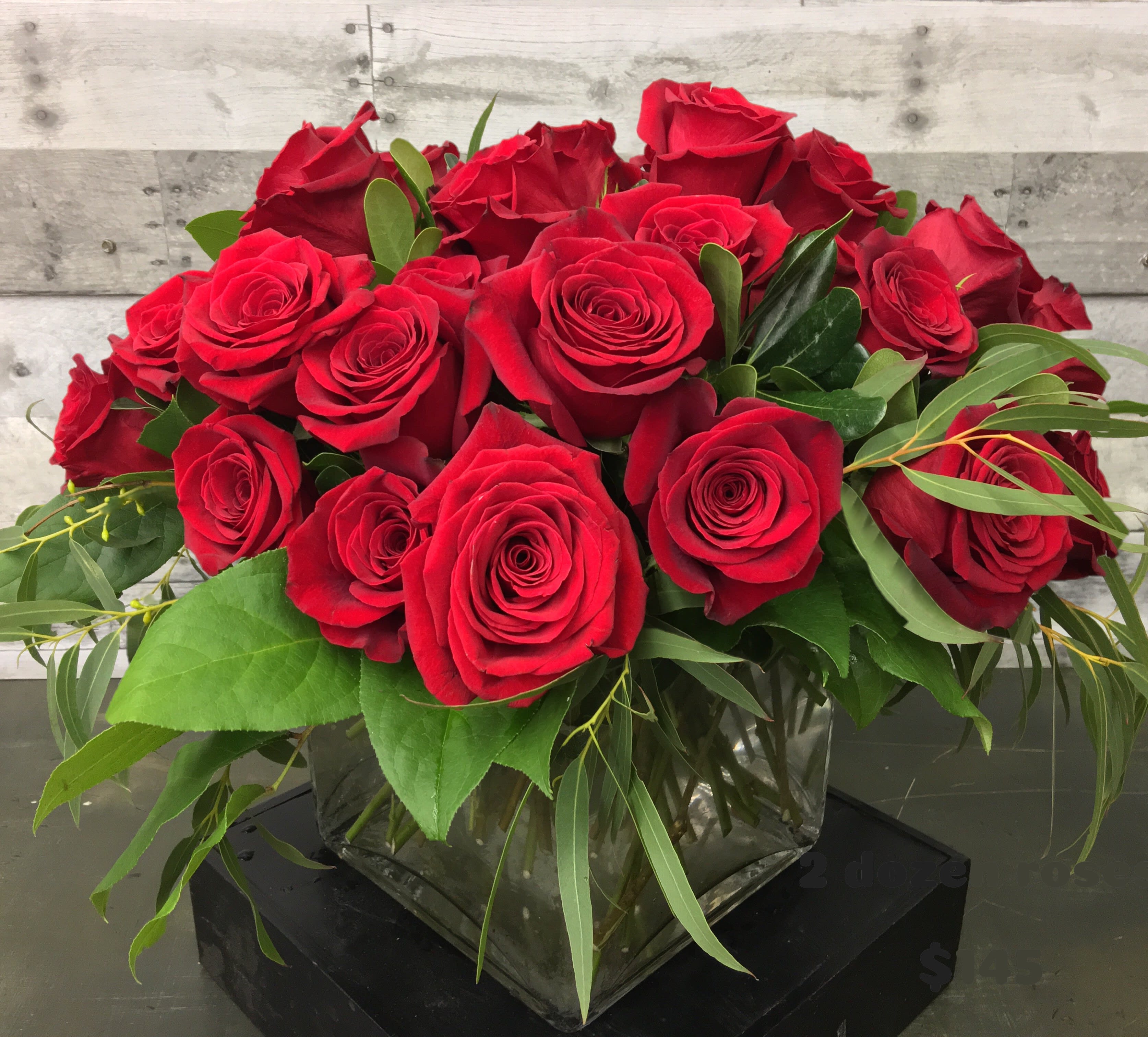 Claude Moore Roses - Beautiful red roses in a large cube vase with eucalyptus and mixed greens.  Classic and timeless. Due to product availability, container may vary.  You can also get these roses in other colors.  Just specify in the special instructions section when placing your order!