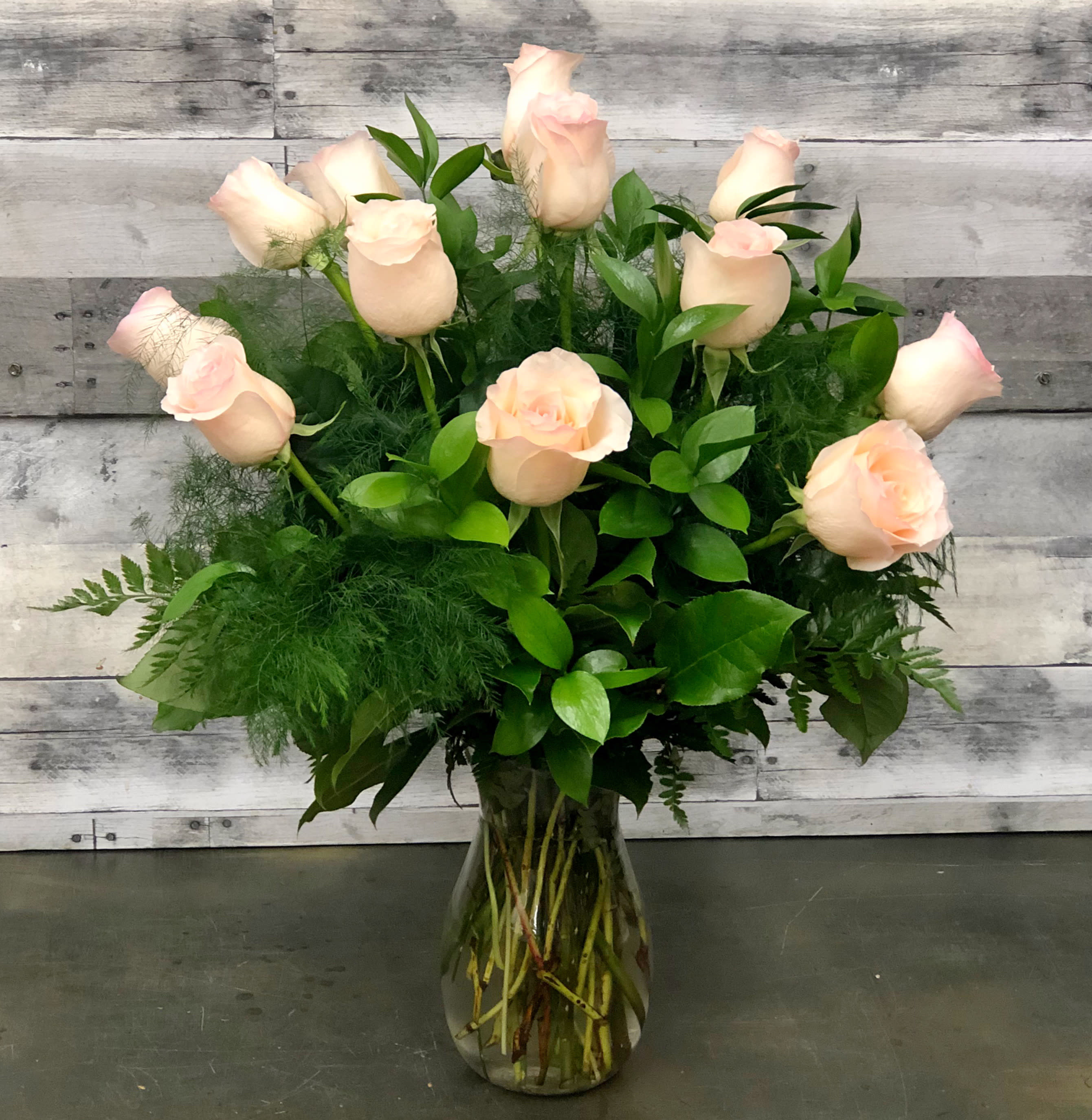 Classic Light Pink Roses - One dozen premium light pink roses arranged in a clear vase. Accent flowers available in the add-on section. Other colors available. Please specify second color choice when placing your order. Deluxe price includes 18 roses, Premium price includes 24 roses. Due to product availability, container may vary. 