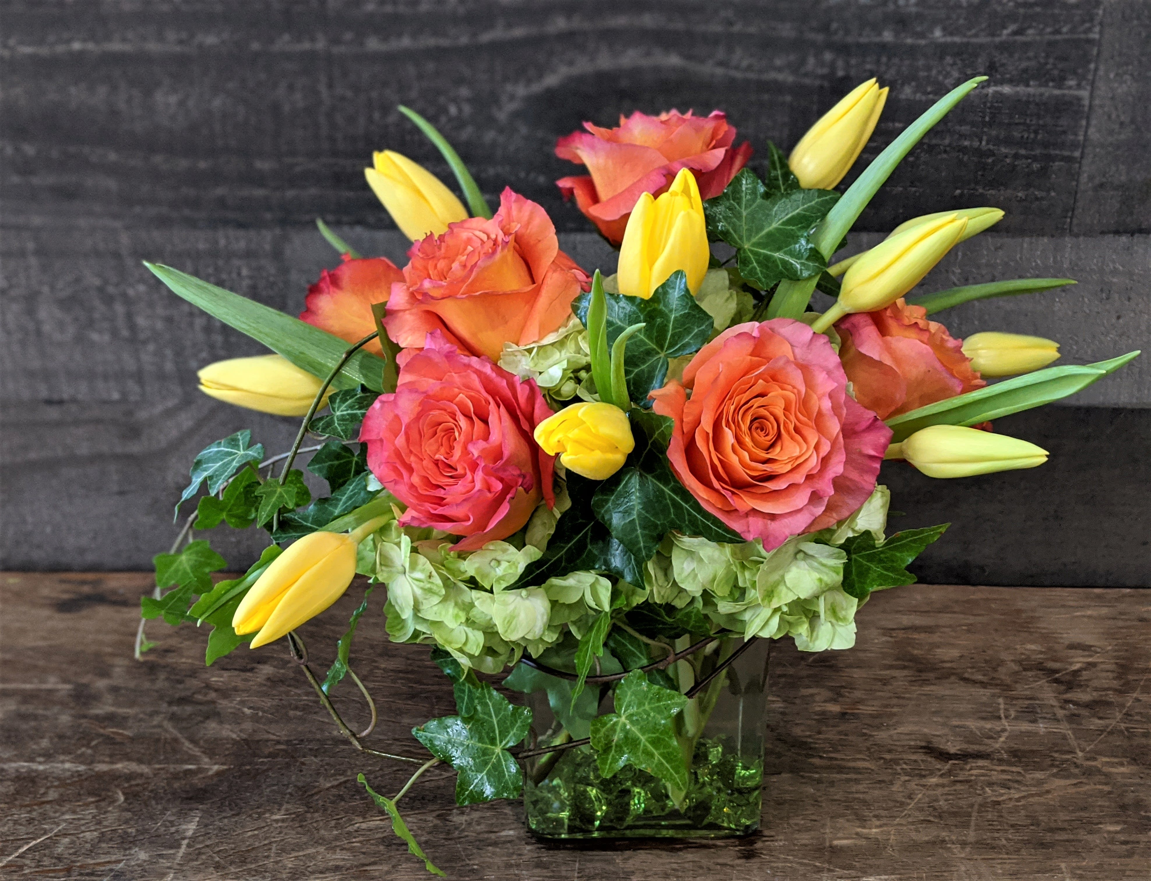Sun Kissed Citrus - Shown as Standard Free spirit roses, hydrangea, tulips and ivy comes arranged in a rectangular vase with accenting acrylic gems. *We custom design this arrangement and use the freshest flowers available the day of delivery. The arrangement in this picture is an example of the size and style and may not feature the exact product shown.*