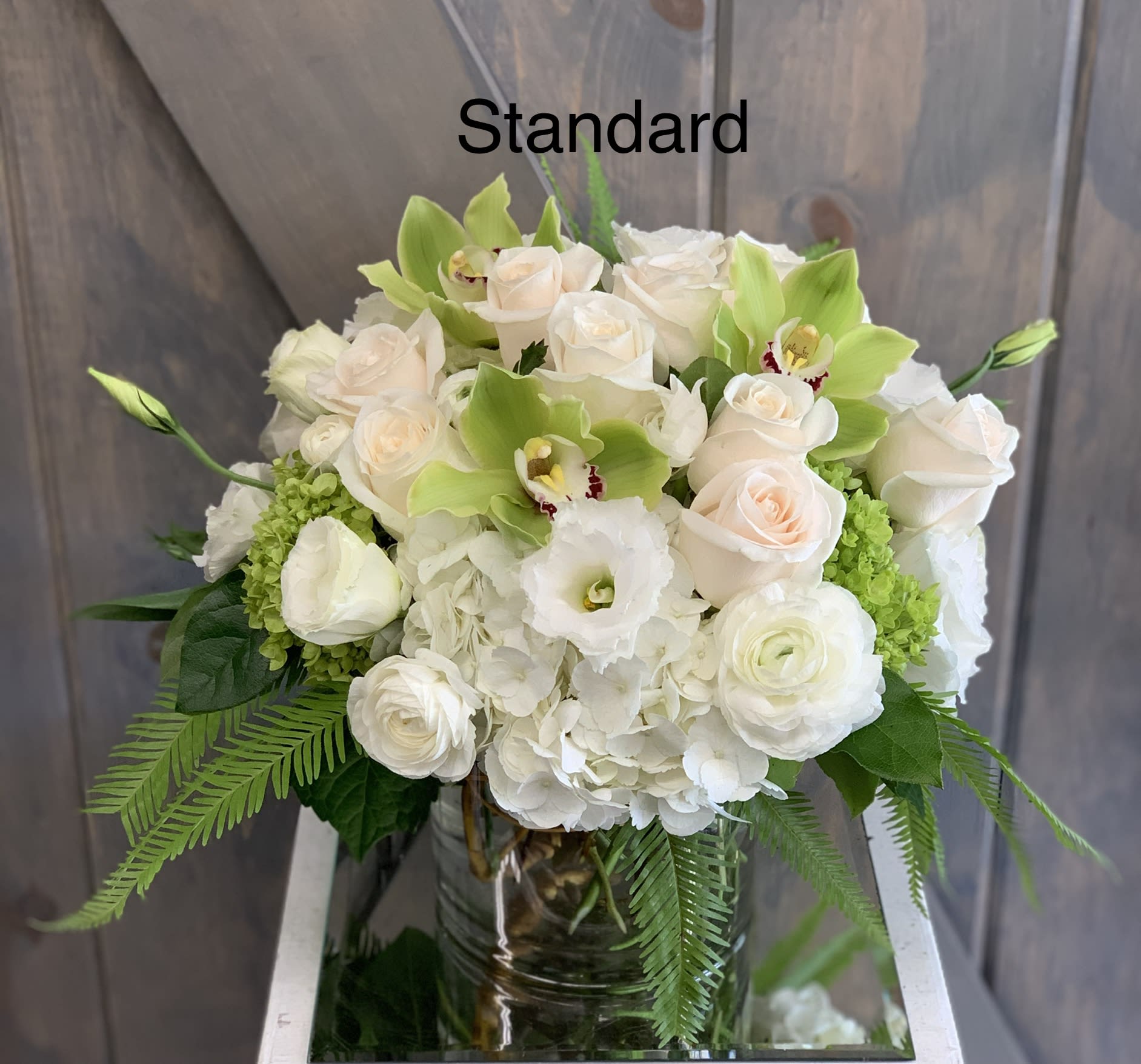 Calming Fern - This elegant and sophicated floral display includes Umbrella fern, White hydrangea, White Roses, Mini green hrangea, Green Cymbidiums, and white Lisianthius