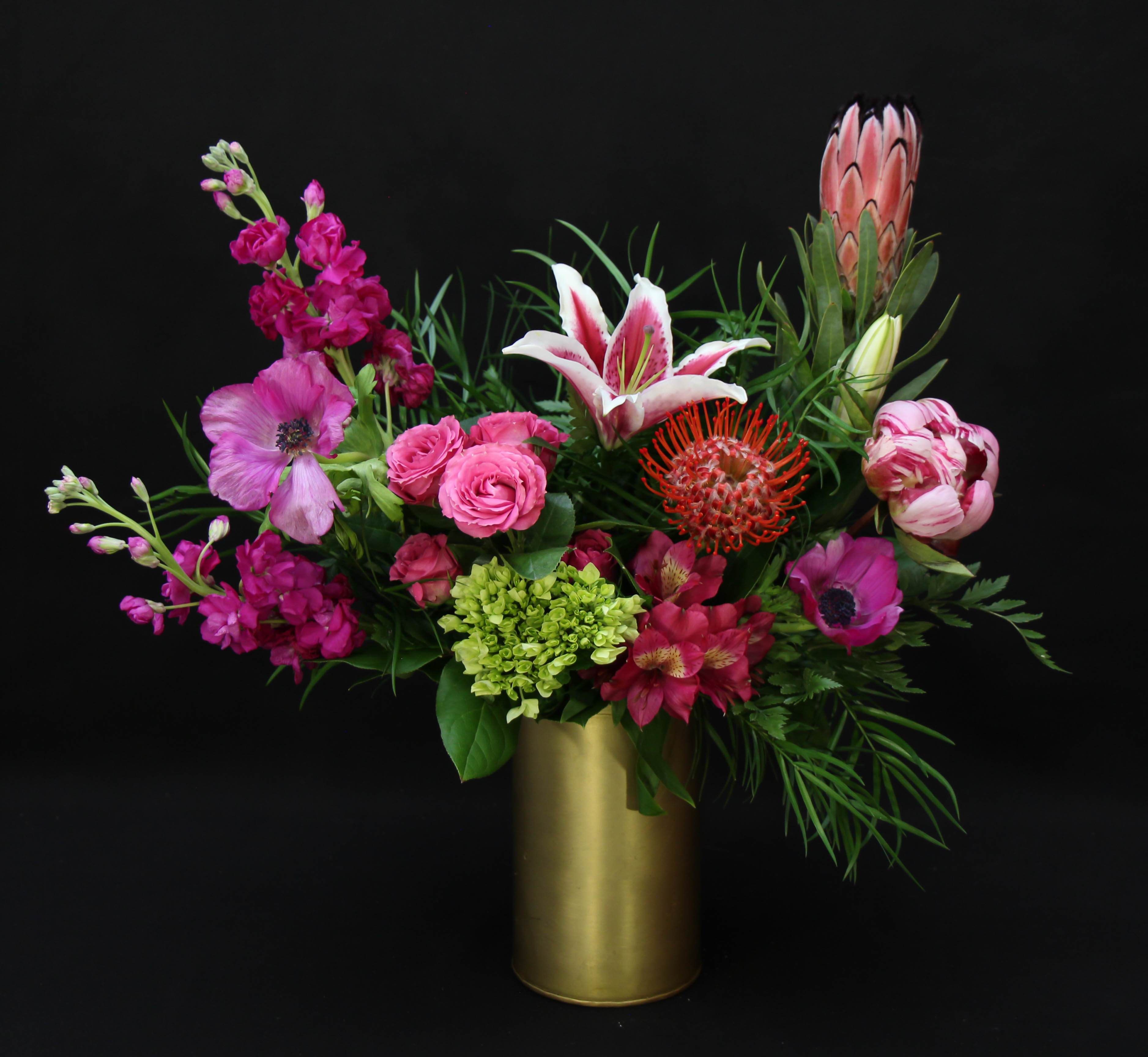 Sweet Escape  - Exotic blooms with a touch of garden love. This lush arrangement is full of vibrant colors that will put a smile on there face!  