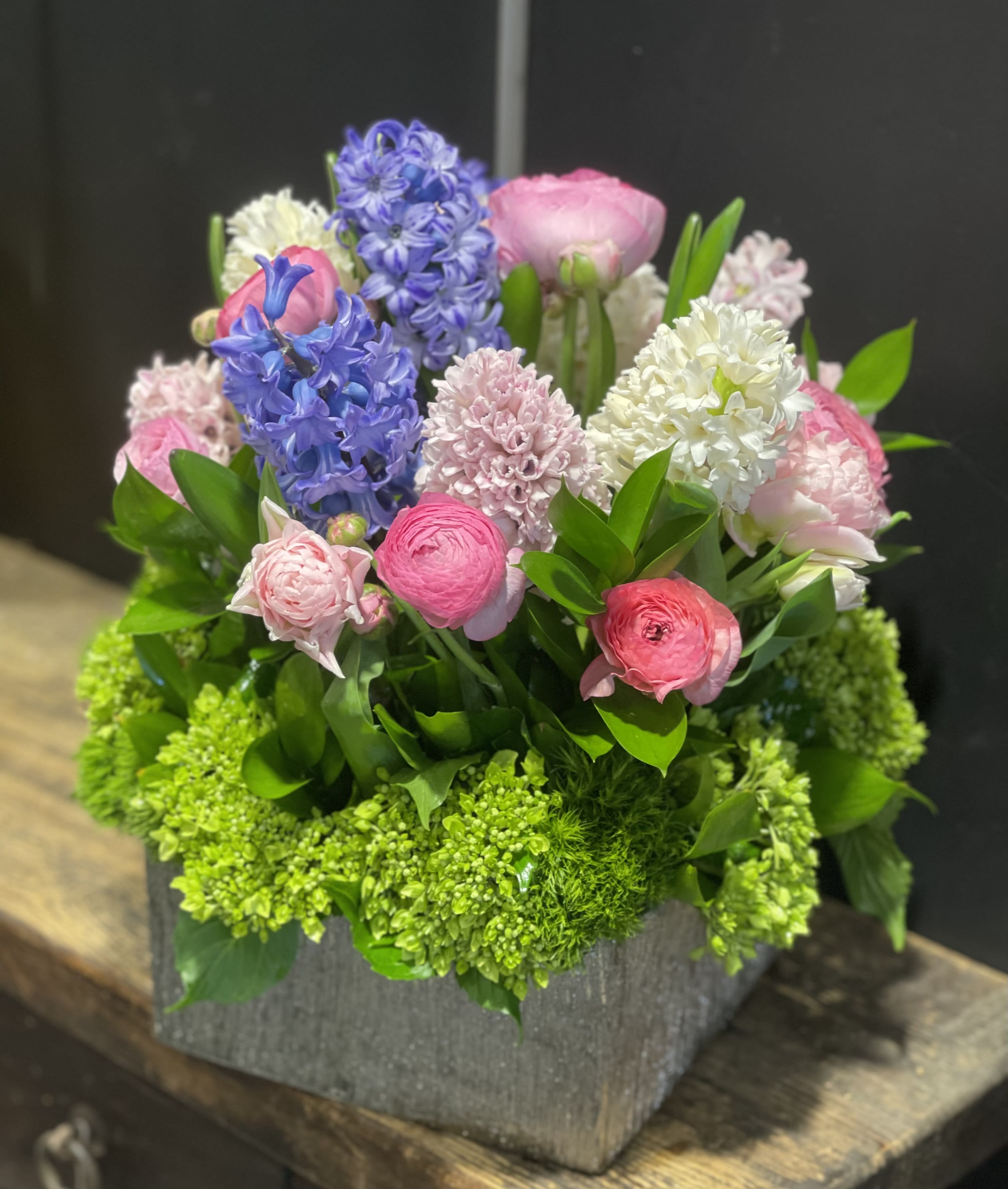 Fragrance - Beautiful combination of Spring flowers like Hyacinth, Tulips, Ranunculus with green mini Hydrangeas in a square container.